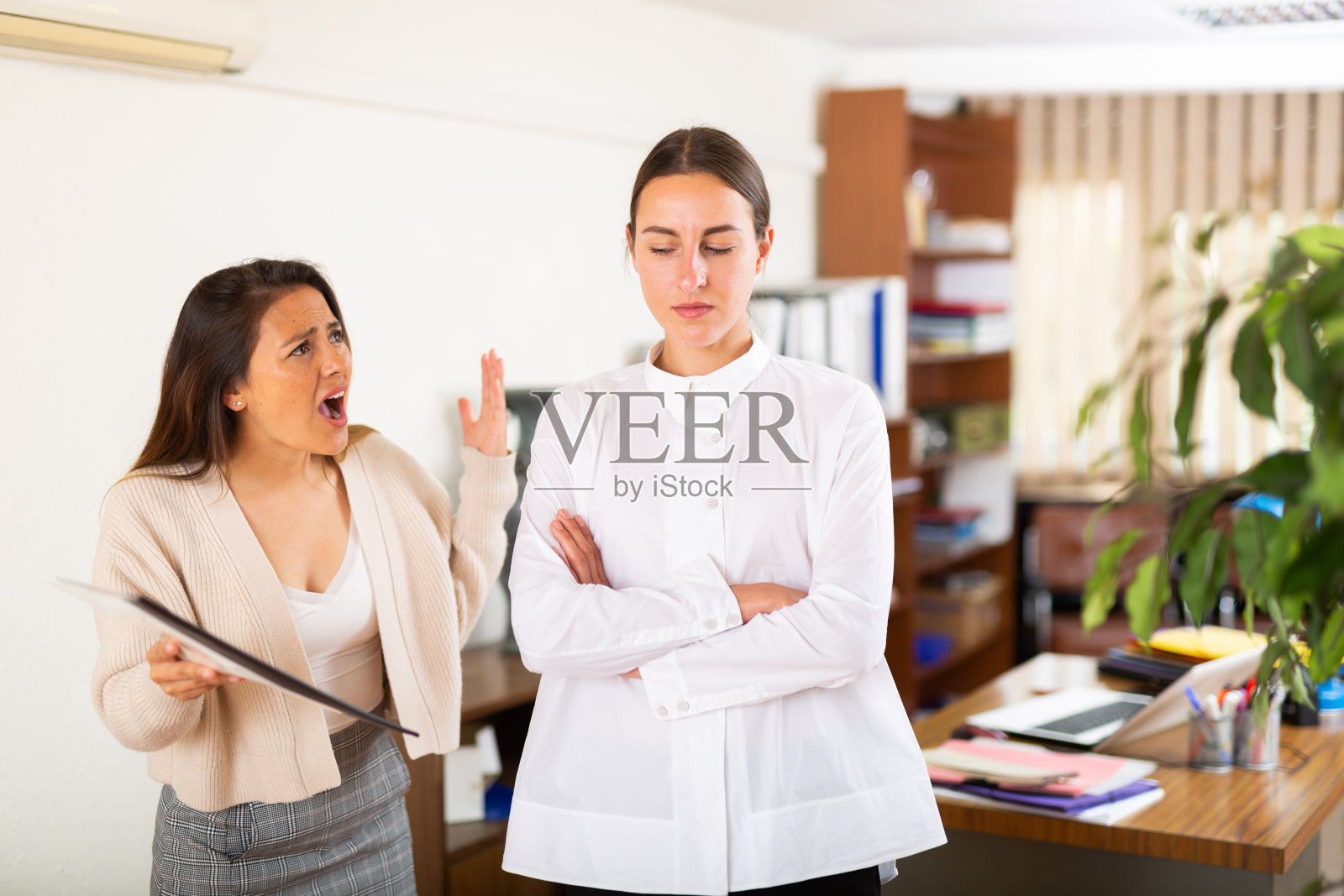 不开心的女主管向年轻的女经理尖叫照片摄影图片