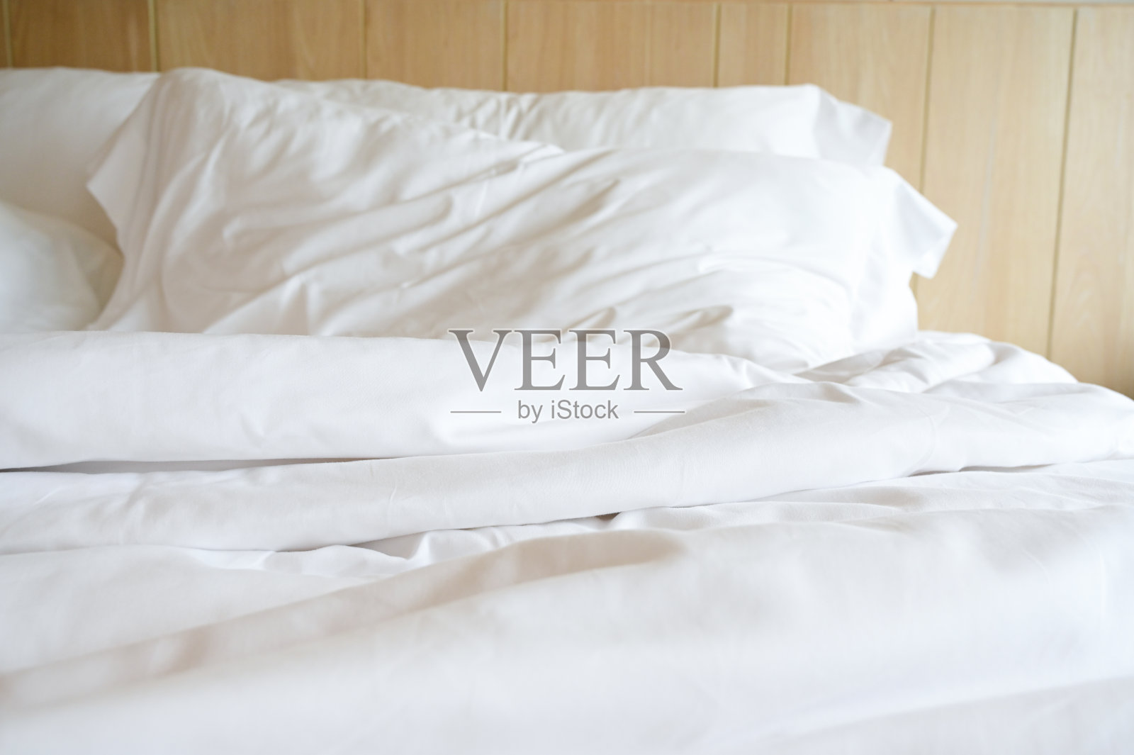 房间里有白色的床和枕头照片摄影图片