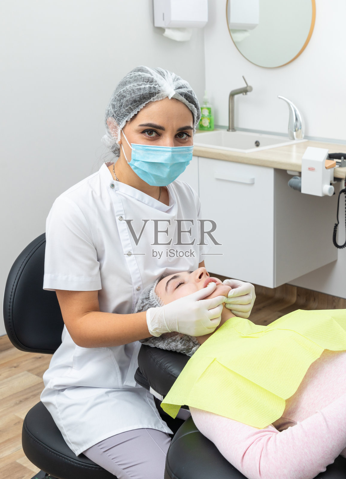 牙科医生正在检查女病人的下颚照片摄影图片