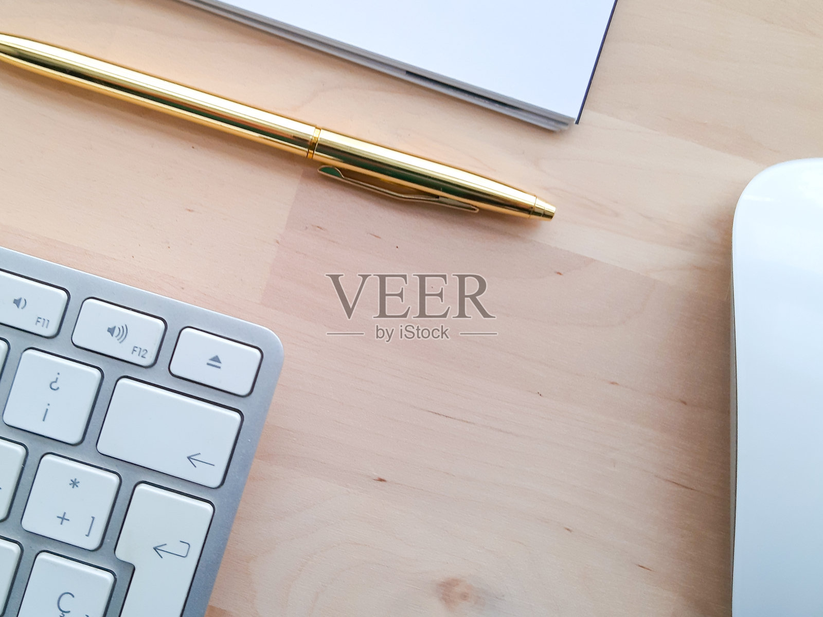 办公桌配有办公配件,办公器物放在木桌上。
居家办公办公桌办公室,电脑,智能手机,白色和金色的钢笔在木桌上照片摄影图片