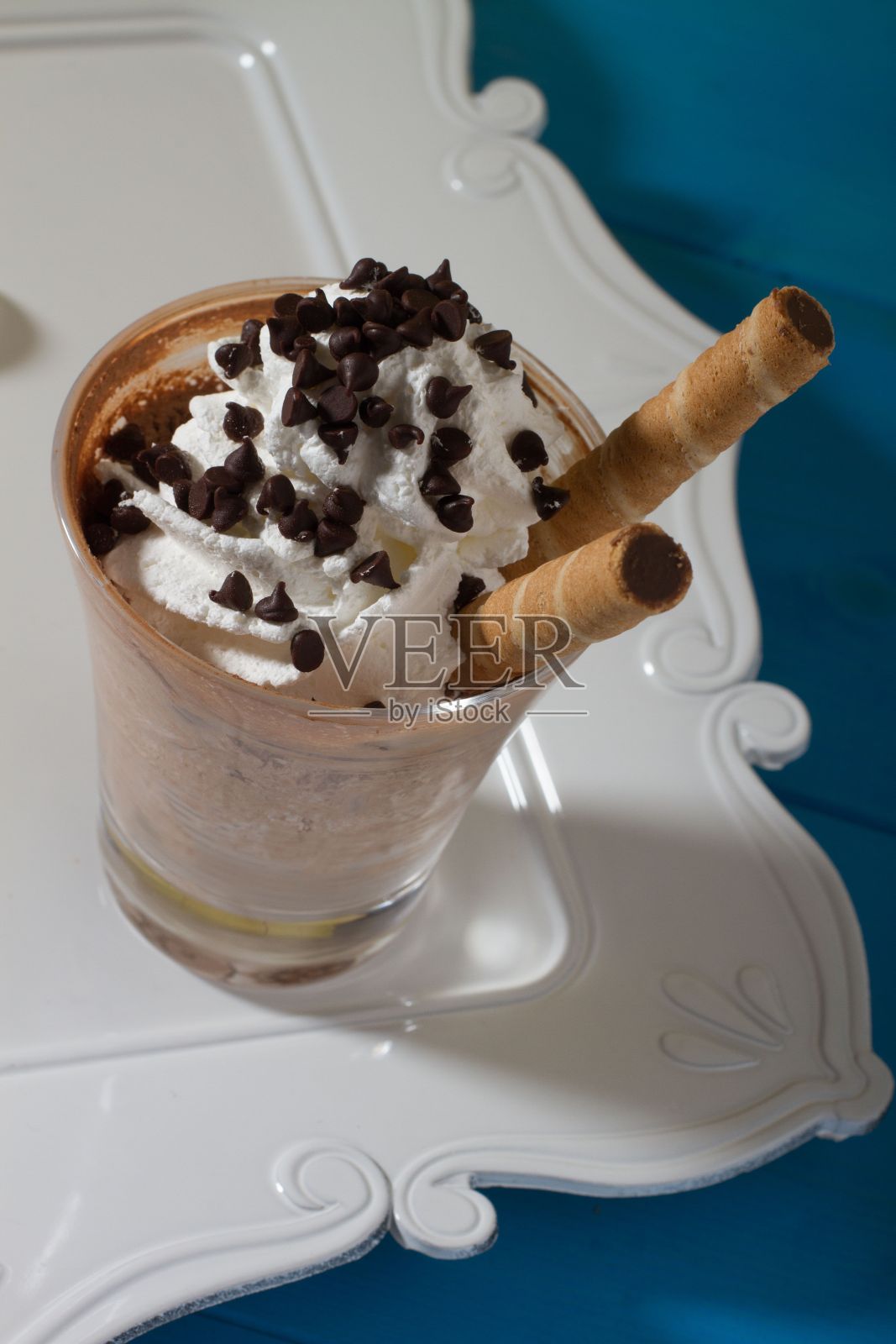 白巧克力冰淇凌放在桌上的白色托盘上。照片摄影图片