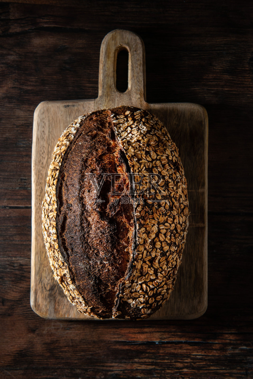 顶部视图的酵母面包与全麦浇头在木板上照片摄影图片