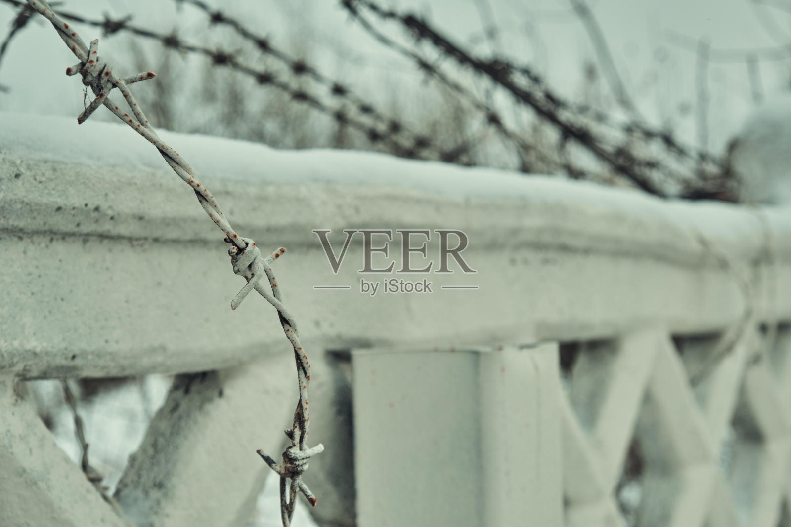 混凝土栅栏上的旧铁丝网,冬天的雪很大特写选择性聚焦照片摄影图片