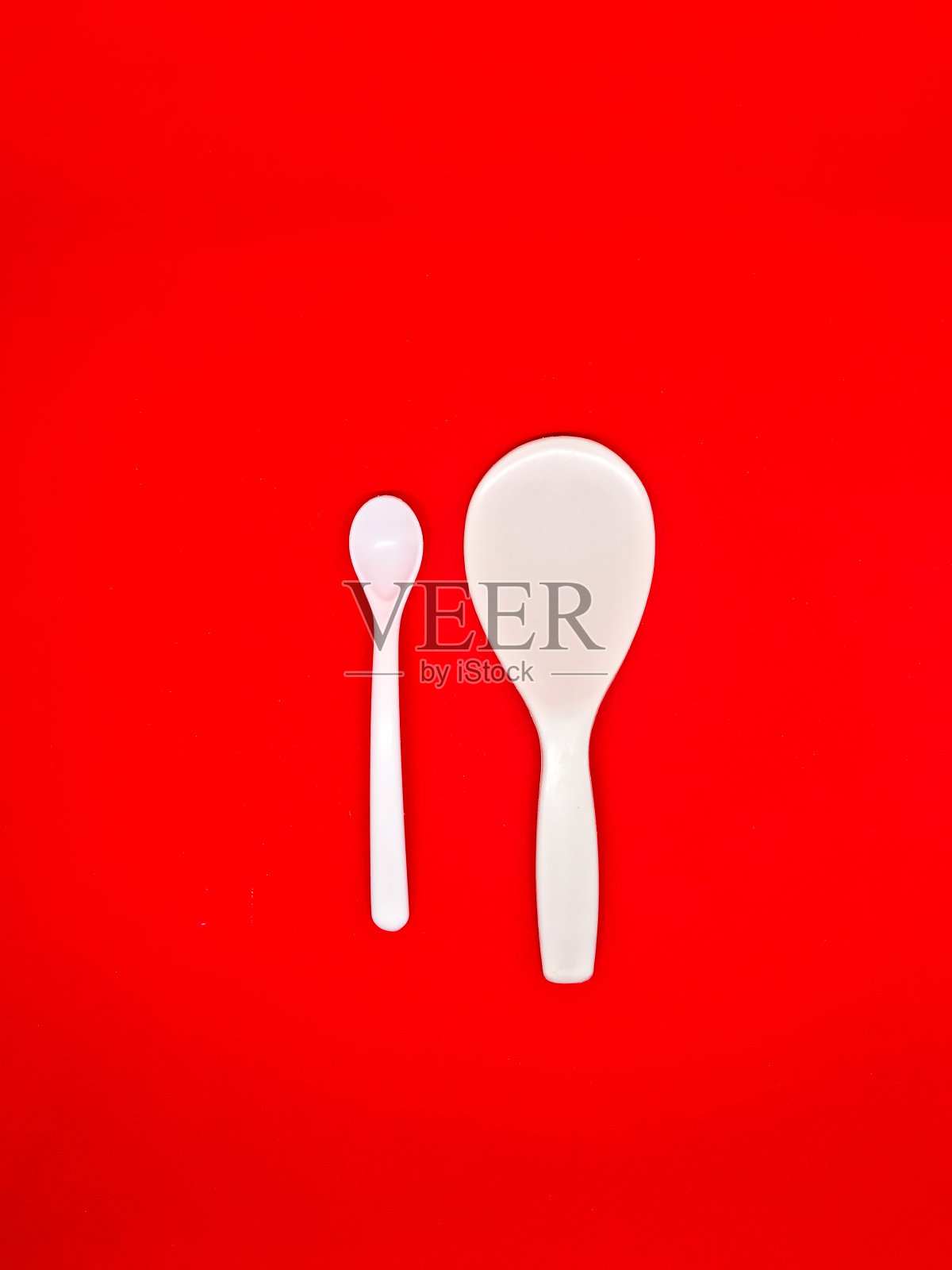 白色的centong和白色的勺子红色的背景照片摄影图片