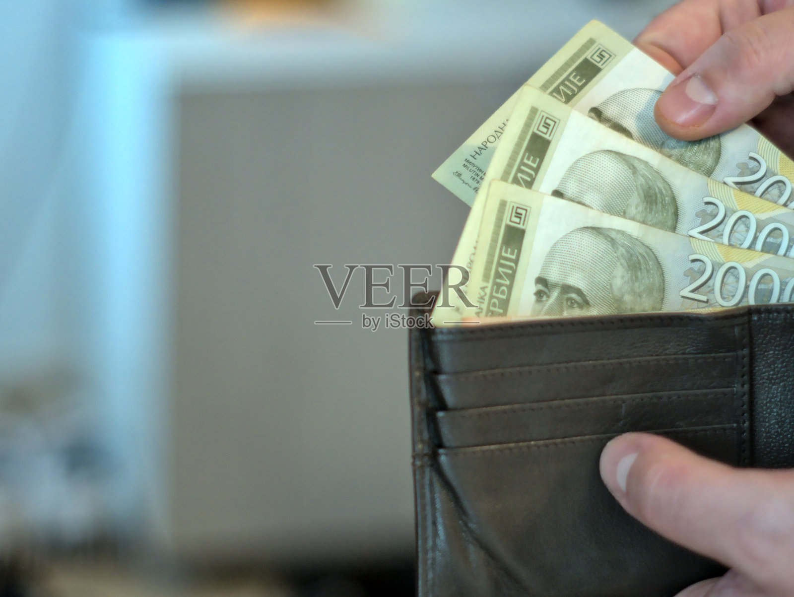 2000塞尔维亚第纳尔钞票的特写镜头。一个人从钱包里拿钱照片摄影图片