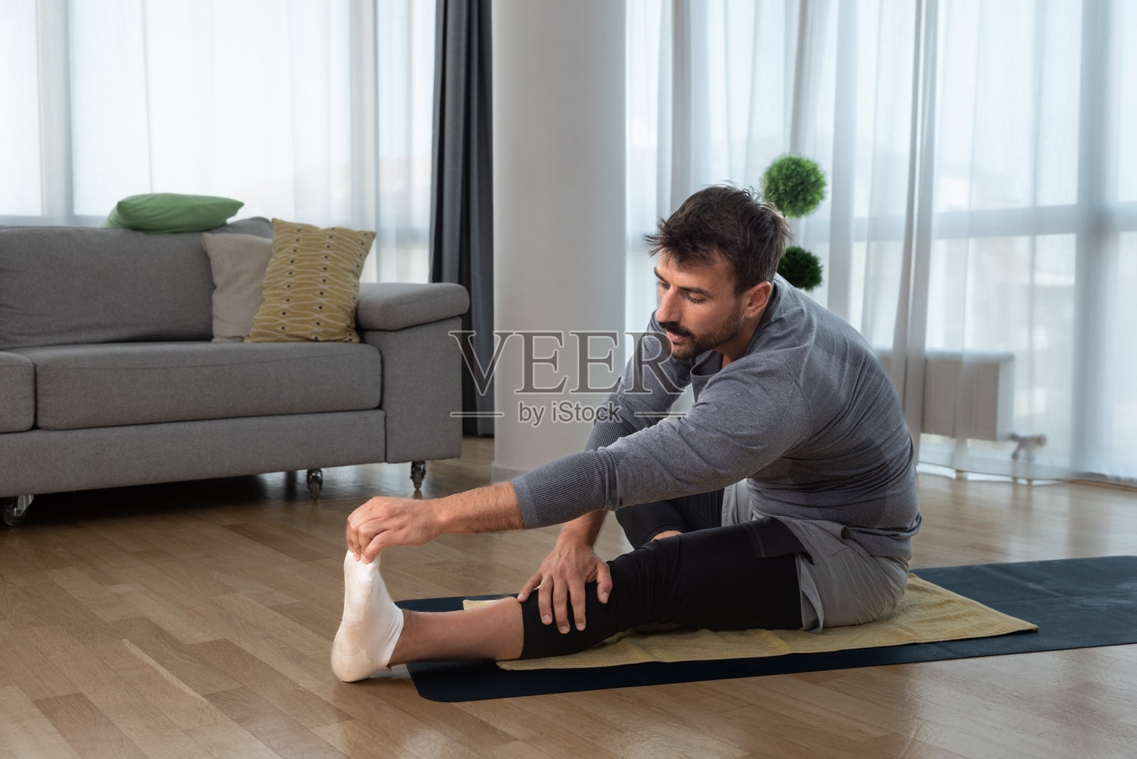 年轻英俊、健康的男人在关系破裂或离婚后开始思考自己,在家里锻炼以改善生活。家庭锻炼动机和自爱观念照片摄影图片