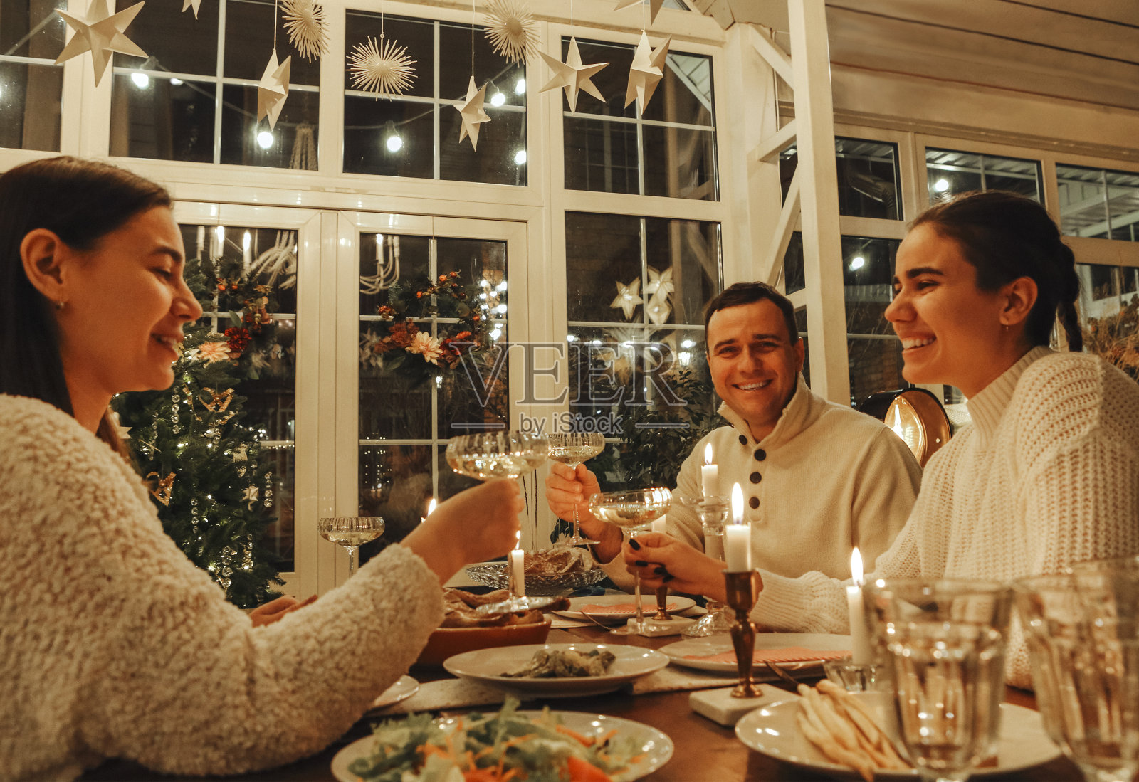 幸福的家庭夫妇碰杯庆祝新年前夜或圣诞节与朋友照片摄影图片