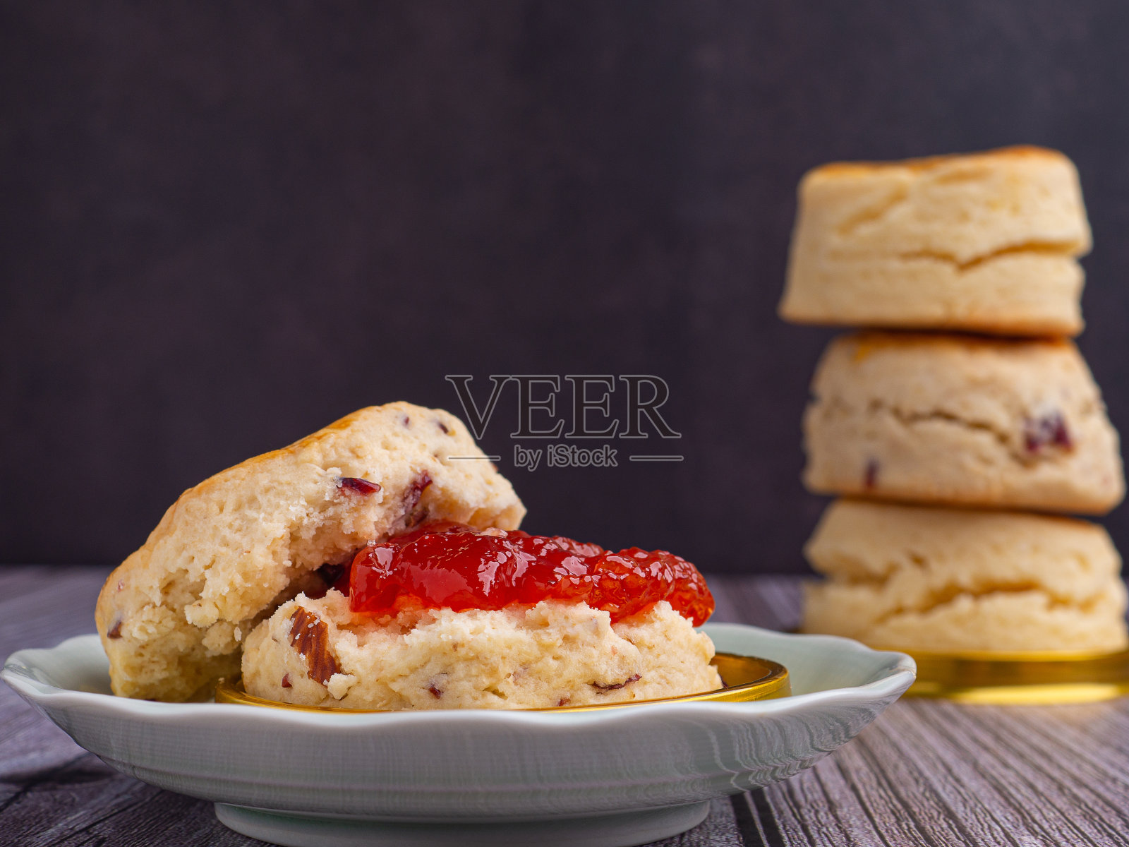 传统的英式烤饼,新鲜出炉的,自制的,草莓酱,放在木桌上的盘子里照片摄影图片