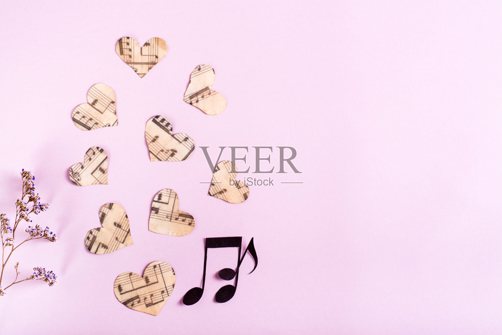 粉色背景上有纸心、纸条和干花。热爱音乐理念。前视图。照片摄影图片