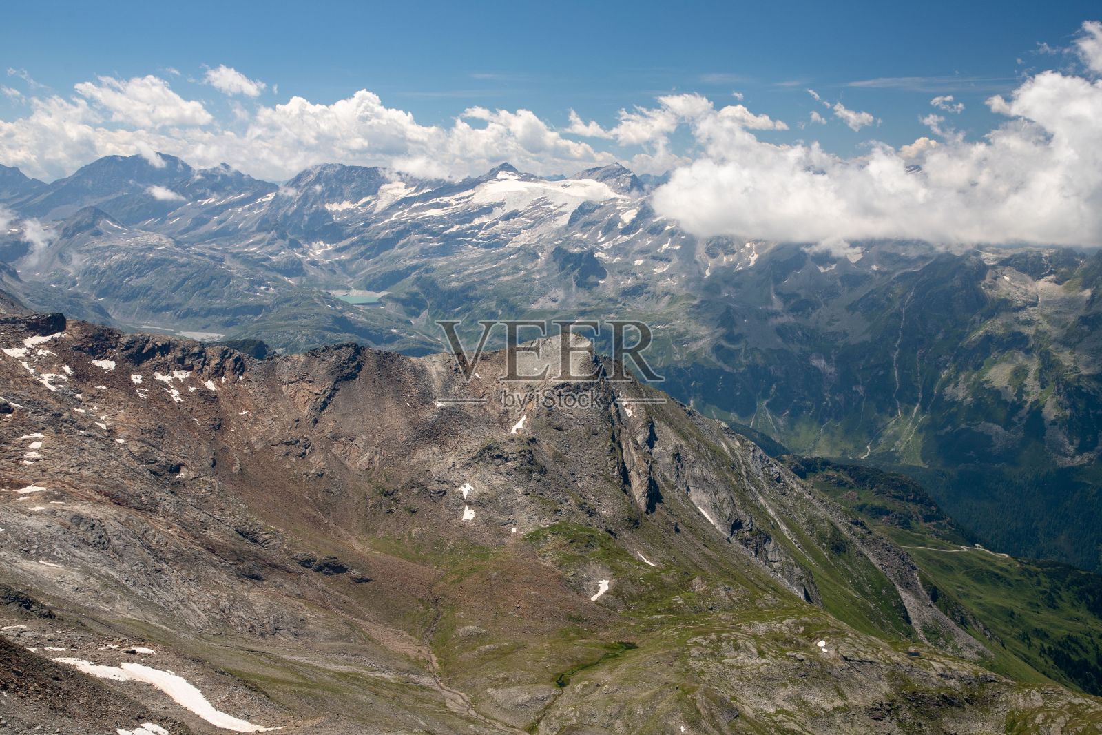 在阳光明媚的日子里,俯瞰岩石嶙峋的阿尔卑斯山脉照片摄影图片