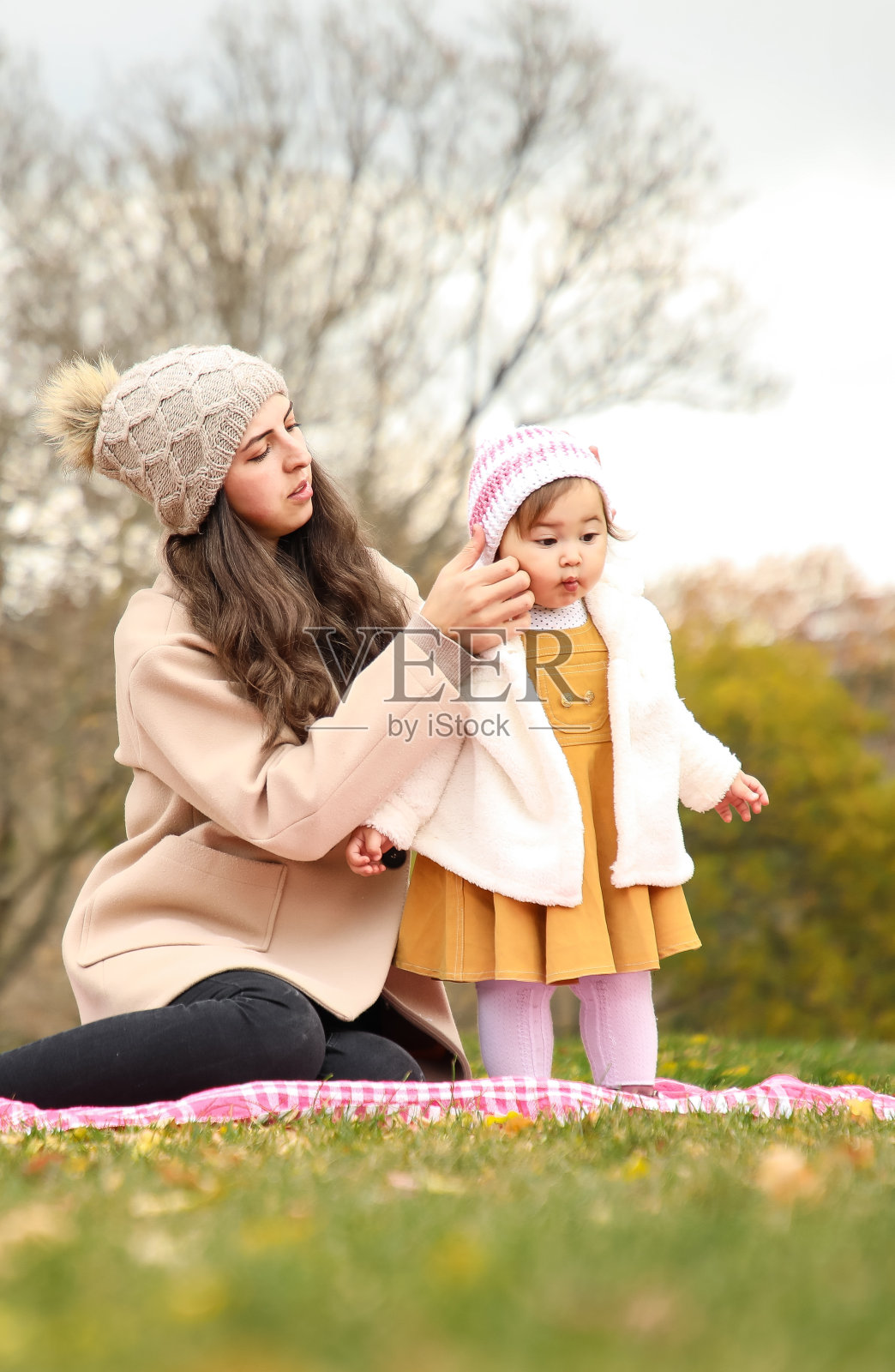 母亲给女儿戴上帽子照片摄影图片