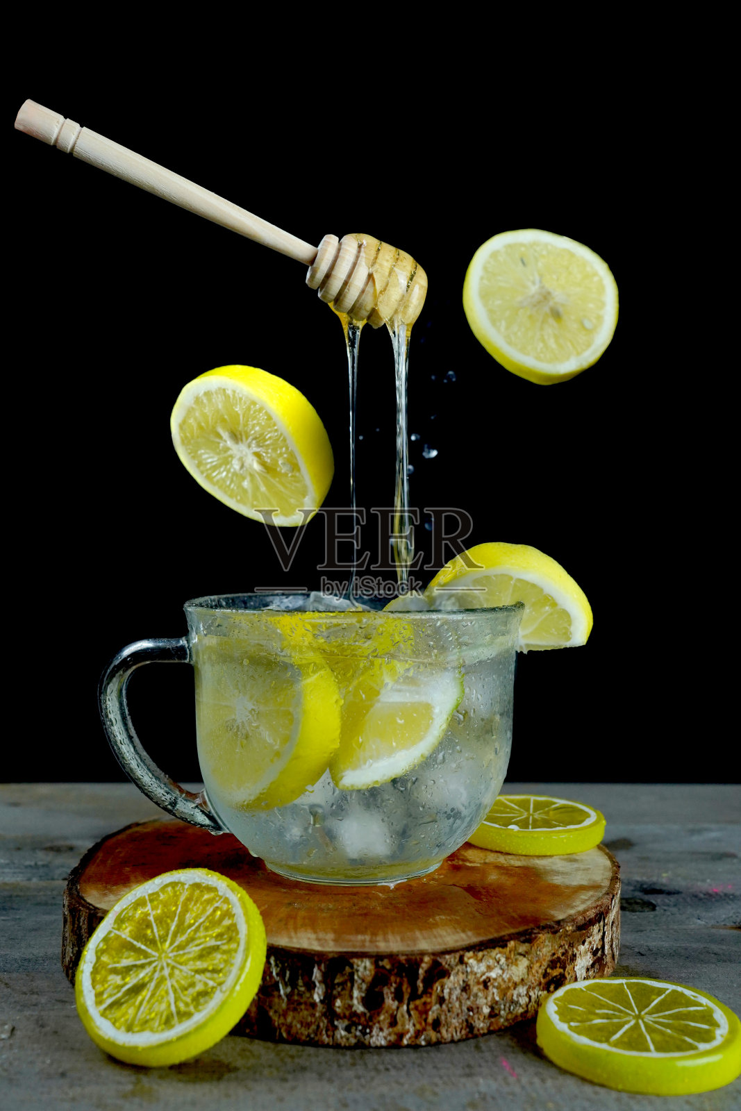 垂直拍摄漂浮的蜂蜜勺冰柠檬水-完美的饮料菜单照片摄影图片