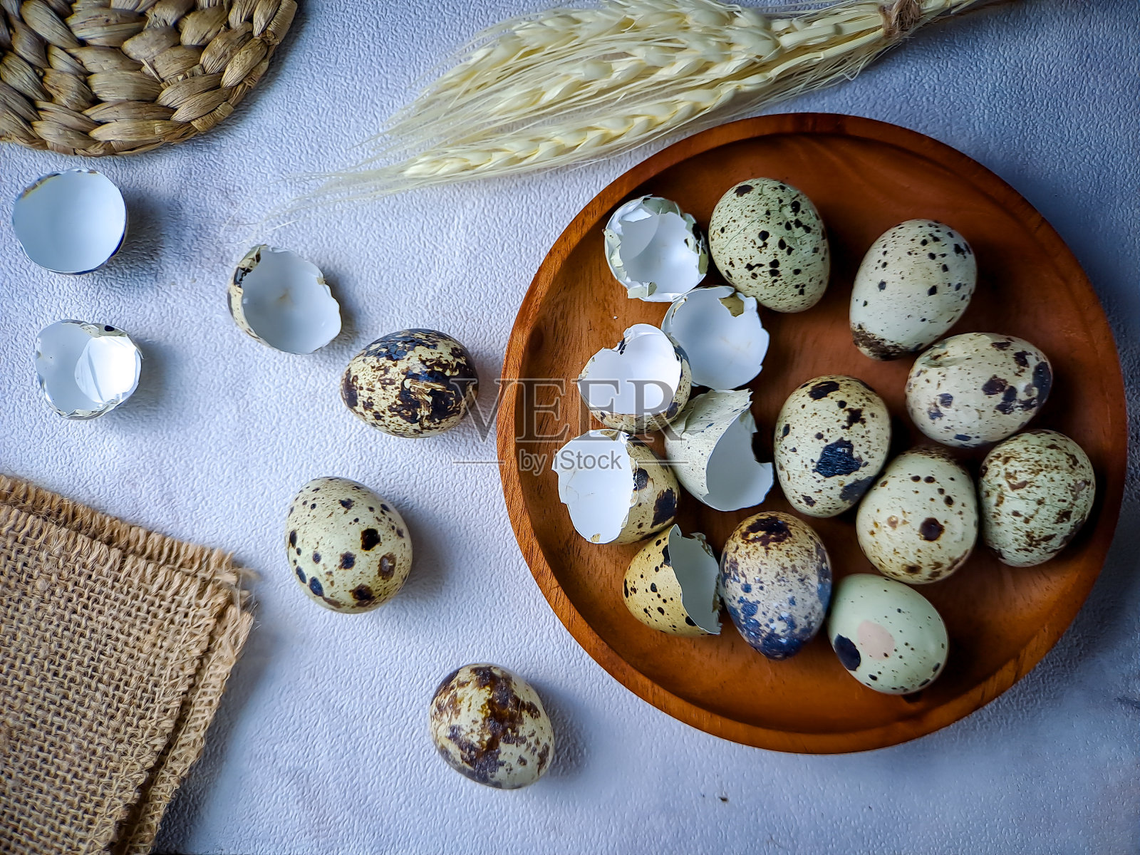 来自鹌鹑的鹌鹑蛋,一堆鹌鹑蛋放在木制盘子上,背景是白色的墙壁照片摄影图片