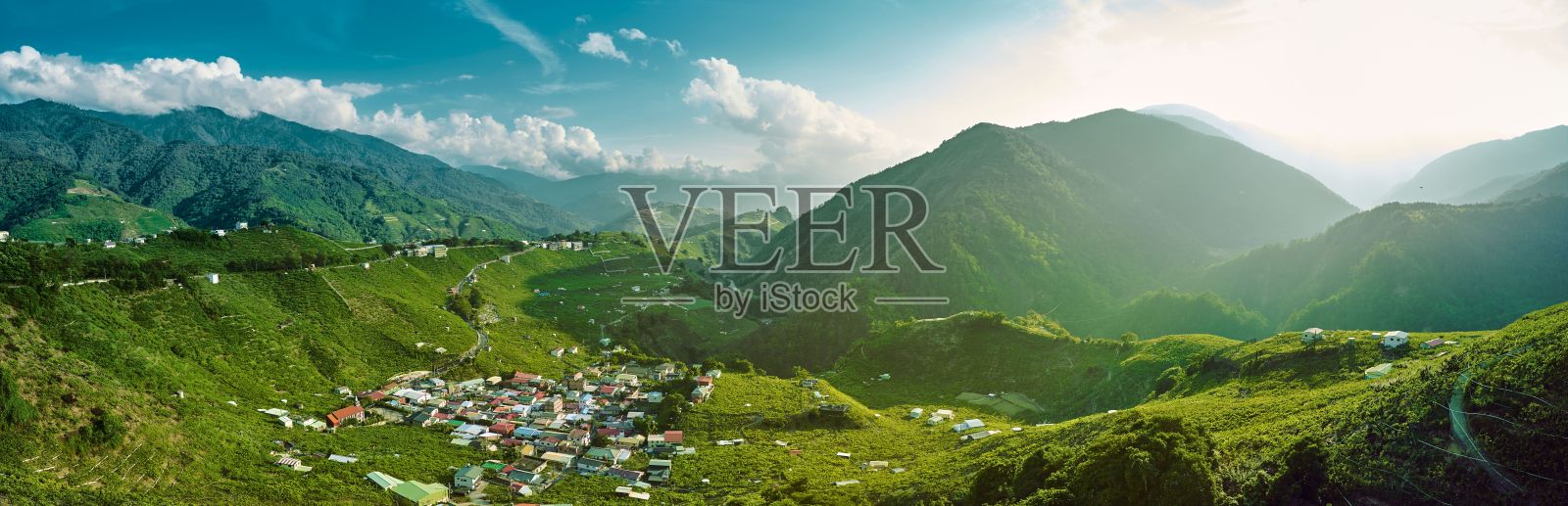 阳光明媚的一天,山谷和小村庄的全景鸟瞰图照片摄影图片