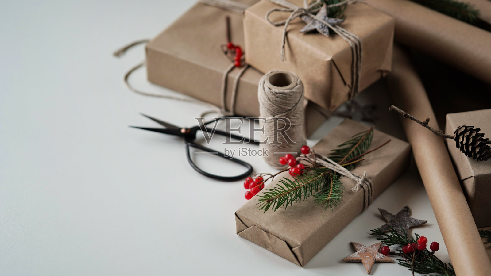 零浪费和环保的圣诞概念。为家人和朋友准备的圣诞和新年礼物用牛皮纸、绳子和天然植物装饰包裹,复制空间,文字空间。有选择性的重点。照片摄影图片