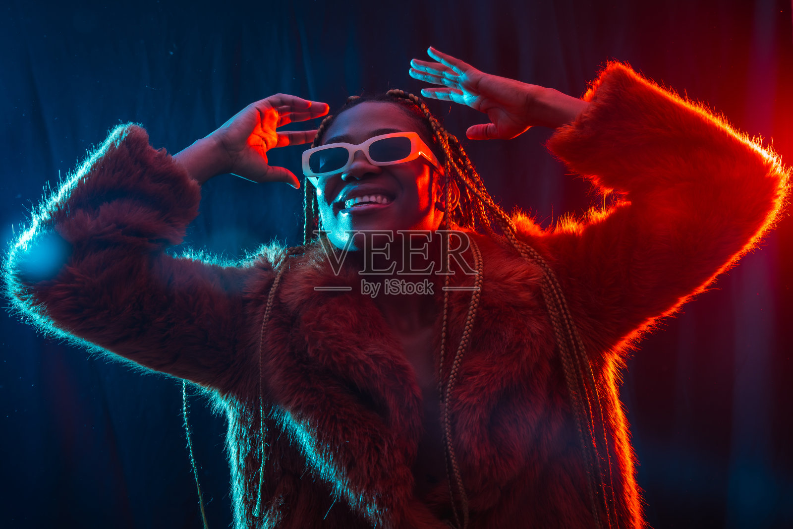 年轻的非洲女人与蓝色和红色的led灯的辫子,陷阱舞者有乐趣照片摄影图片