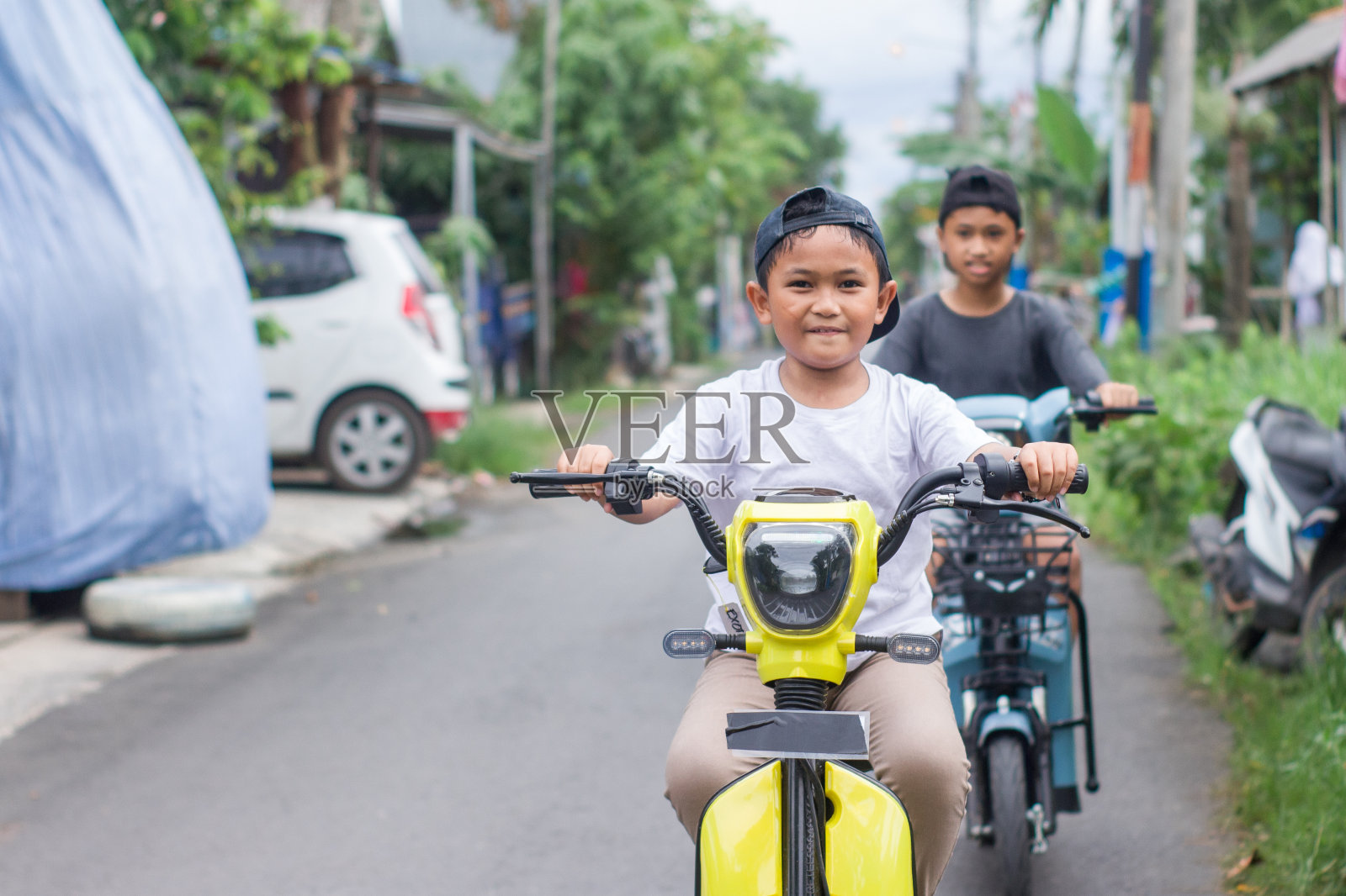 男孩在小区骑着电动车,一起出去玩照片摄影图片
