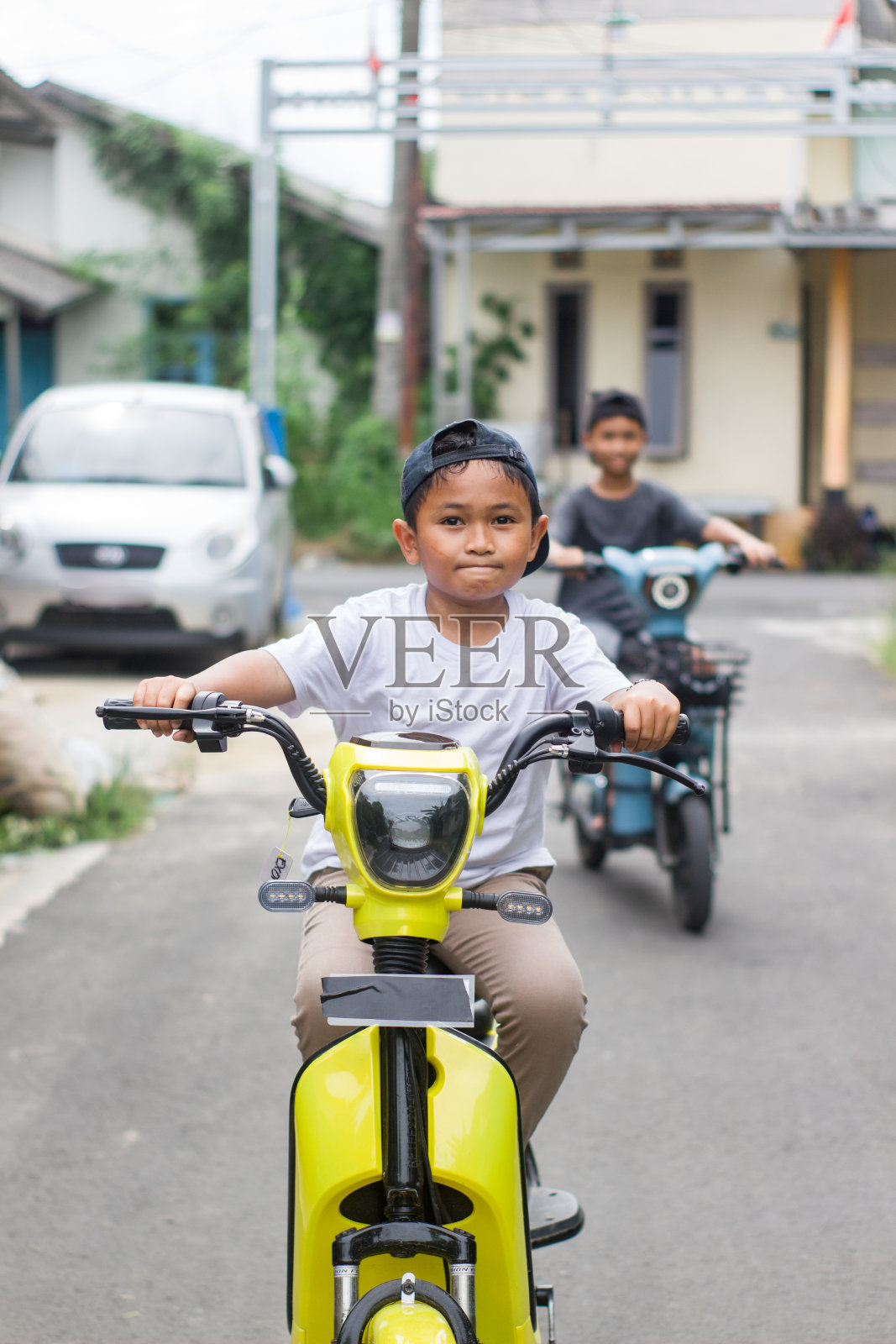 男孩在小区骑着电动车,一起出去玩照片摄影图片