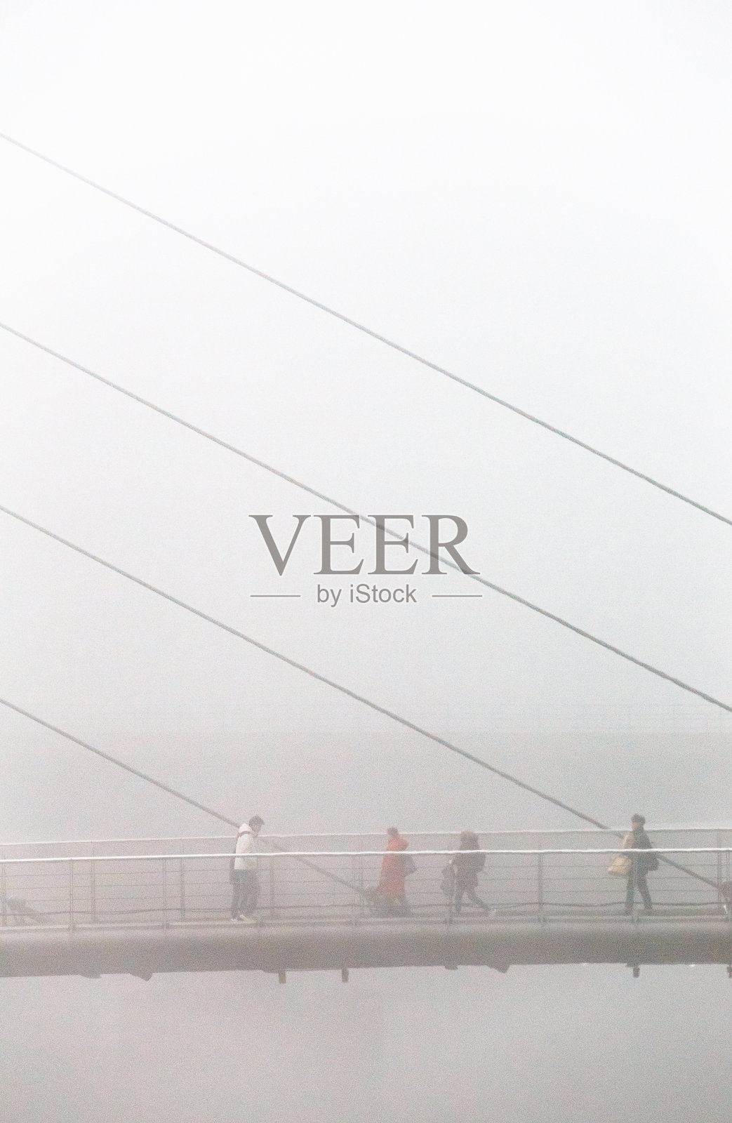 在大雾天,英国伦敦市中心,通勤者走过桥照片摄影图片