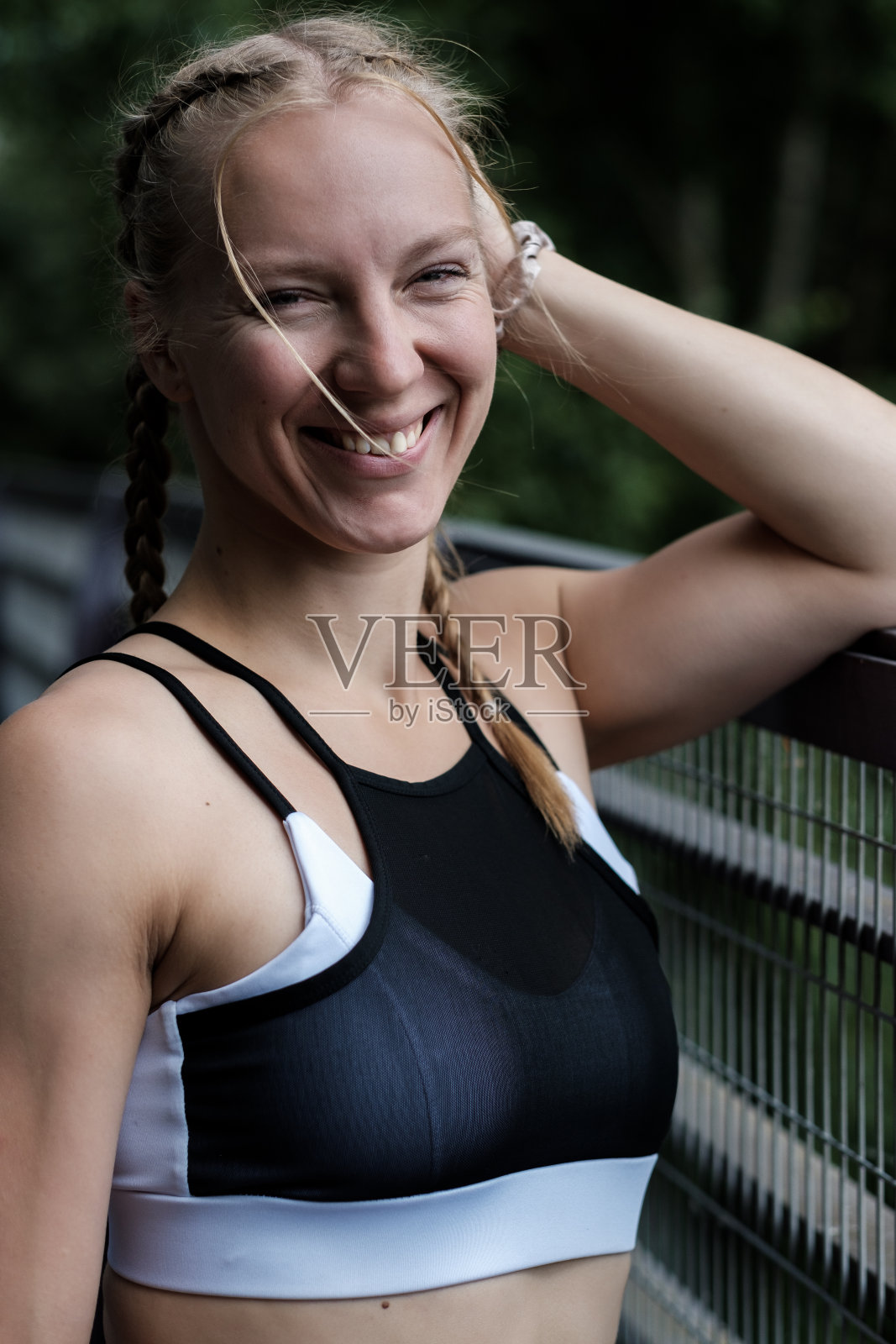 微笑的运动年轻白人女子穿着运动胸罩看着相机的肖像。照片摄影图片