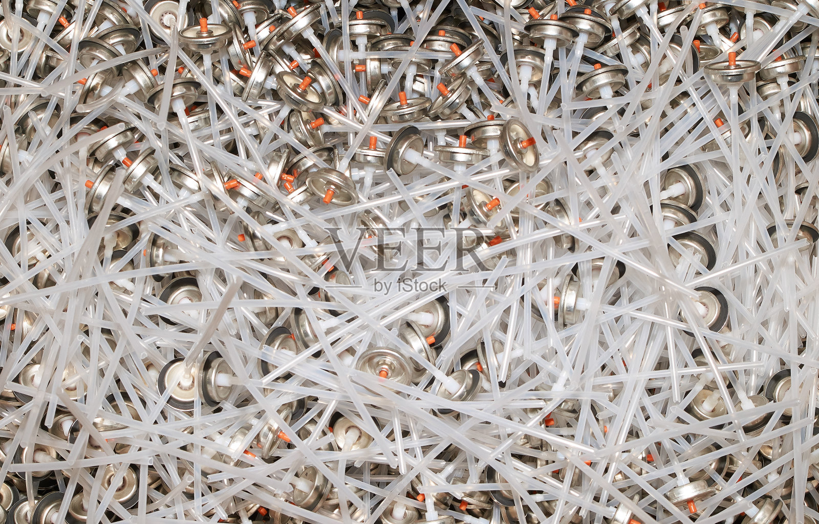 大量用于涂鸦的喷雾剂油漆罐的瓶盖。涂满彩色油漆的喷嘴堆成一大堆照片摄影图片