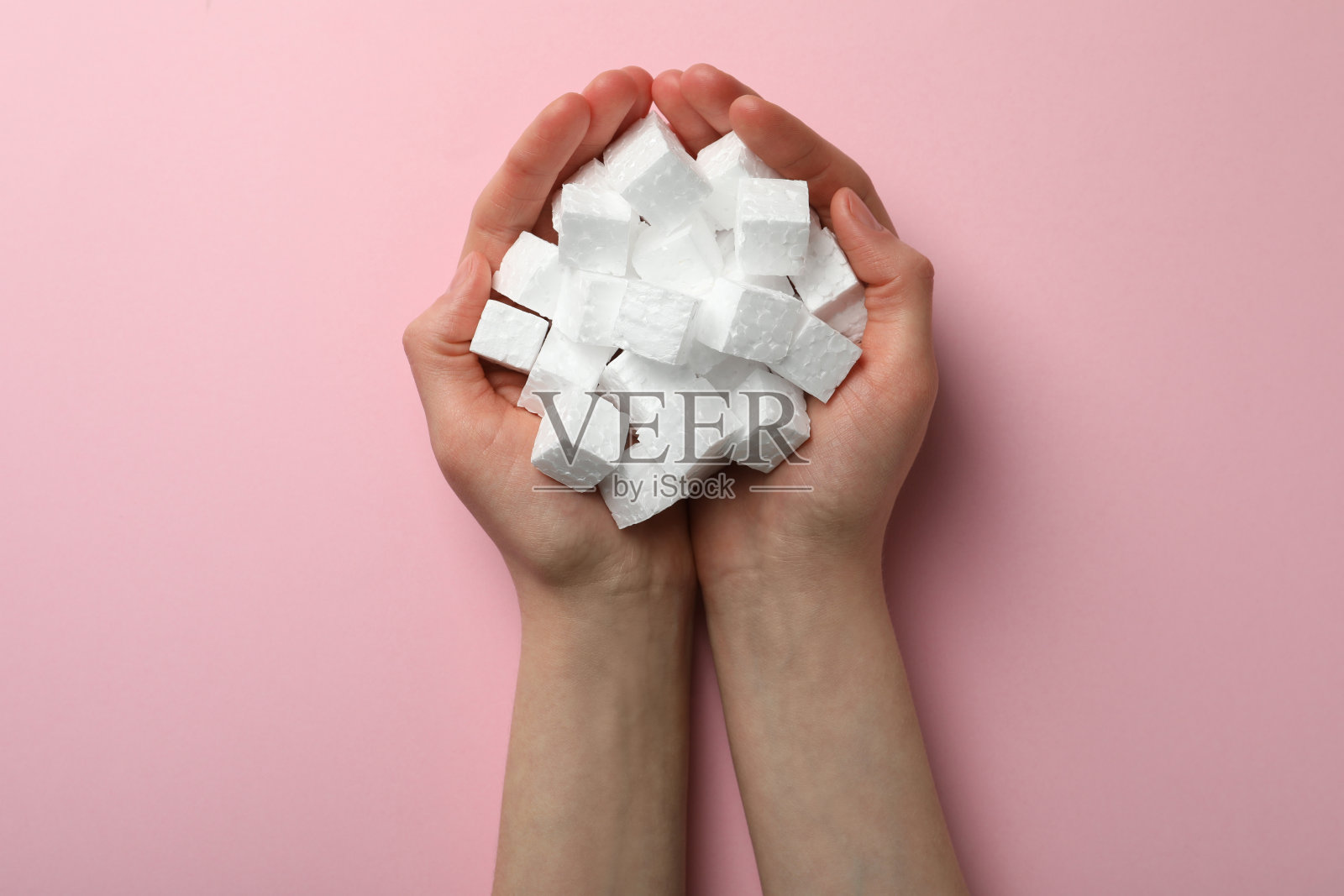 女子与一把泡沫聚苯乙烯立方体在粉红色的背景,俯视图照片摄影图片