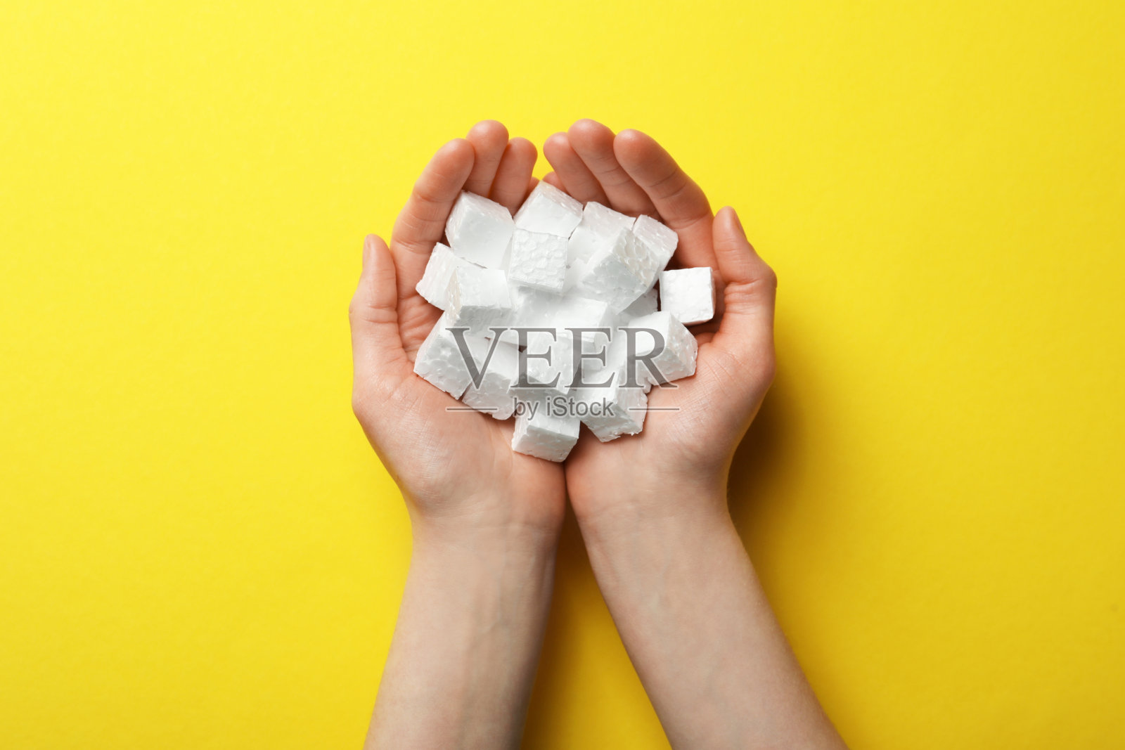 女子与一把泡沫聚苯乙烯立方体在黄色背景,俯视图照片摄影图片