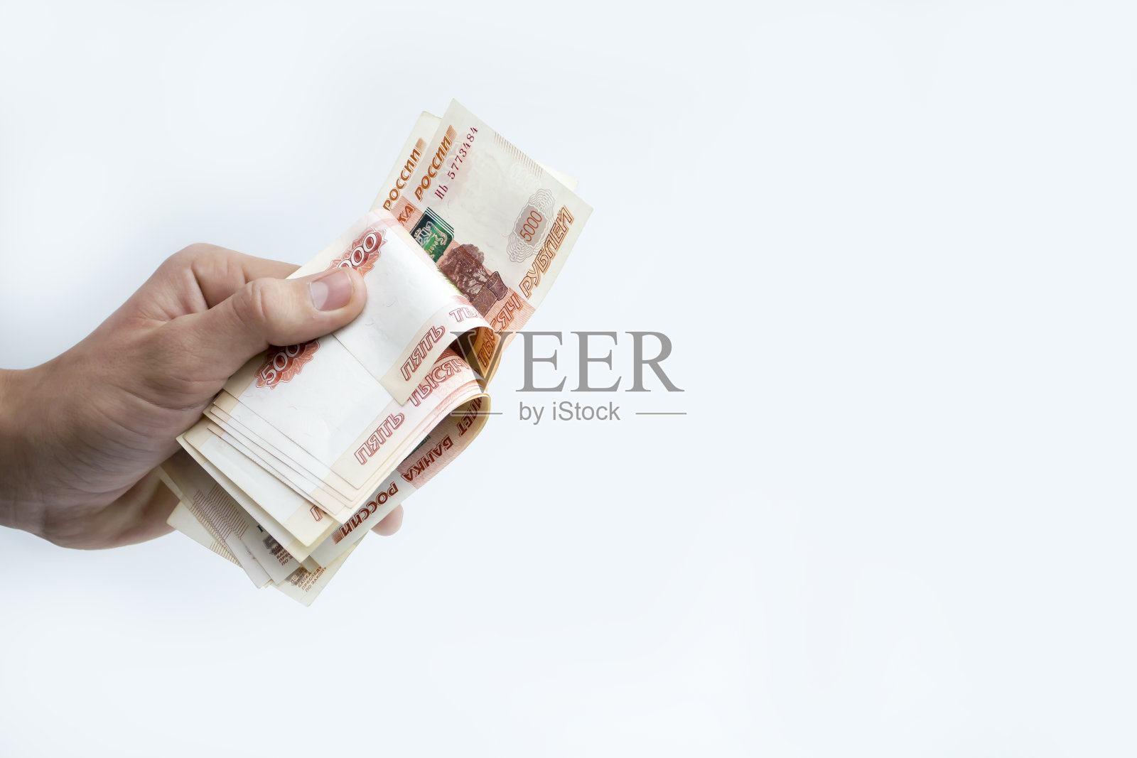 这只手握着5000卢布。重新计算资金。照片摄影图片