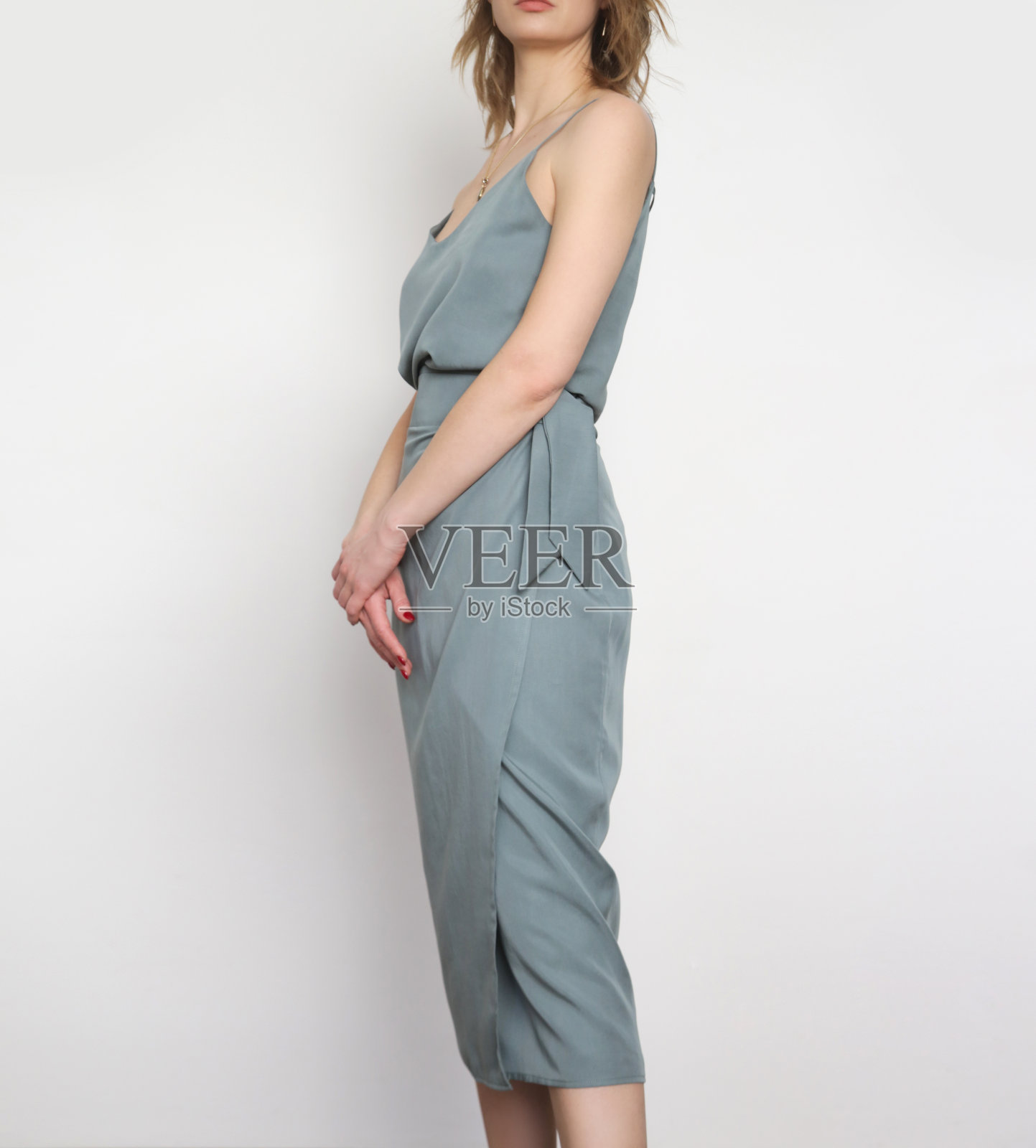 女模特穿着蓝灰色背心丝绸上衣和包裹中长裙。时尚的单色夏日套装。时尚工作室拍摄。照片摄影图片