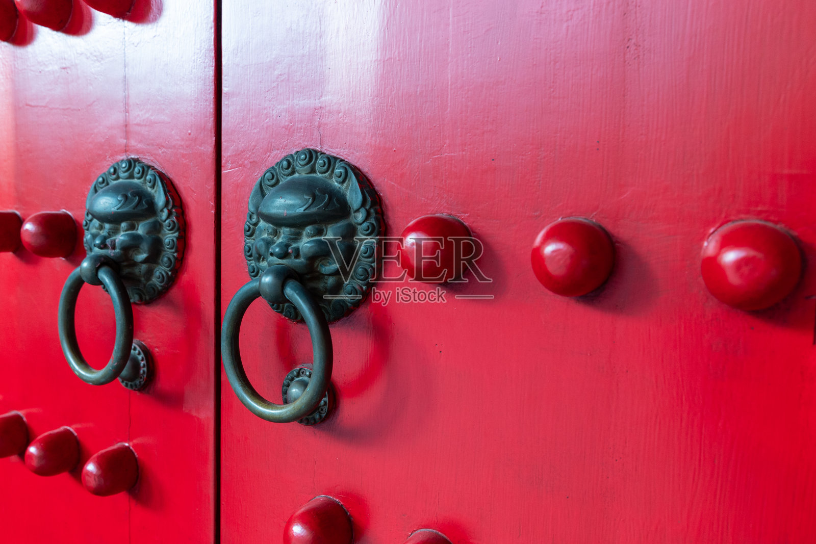 红色木门上的中式狮子门环特写照片摄影图片