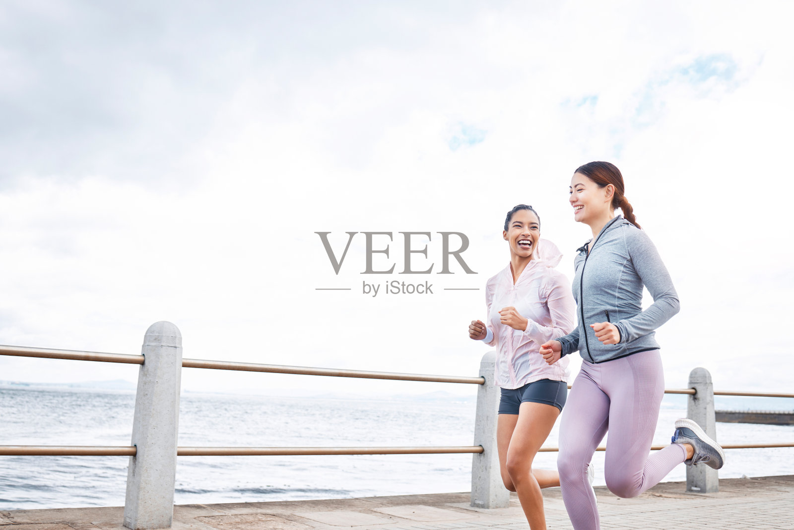 跑步、健身和女性朋友通过海洋进行户外健康、责任感或锻炼动机模拟营销或广告。体育运动员为了健康的生活方式而运动照片摄影图片