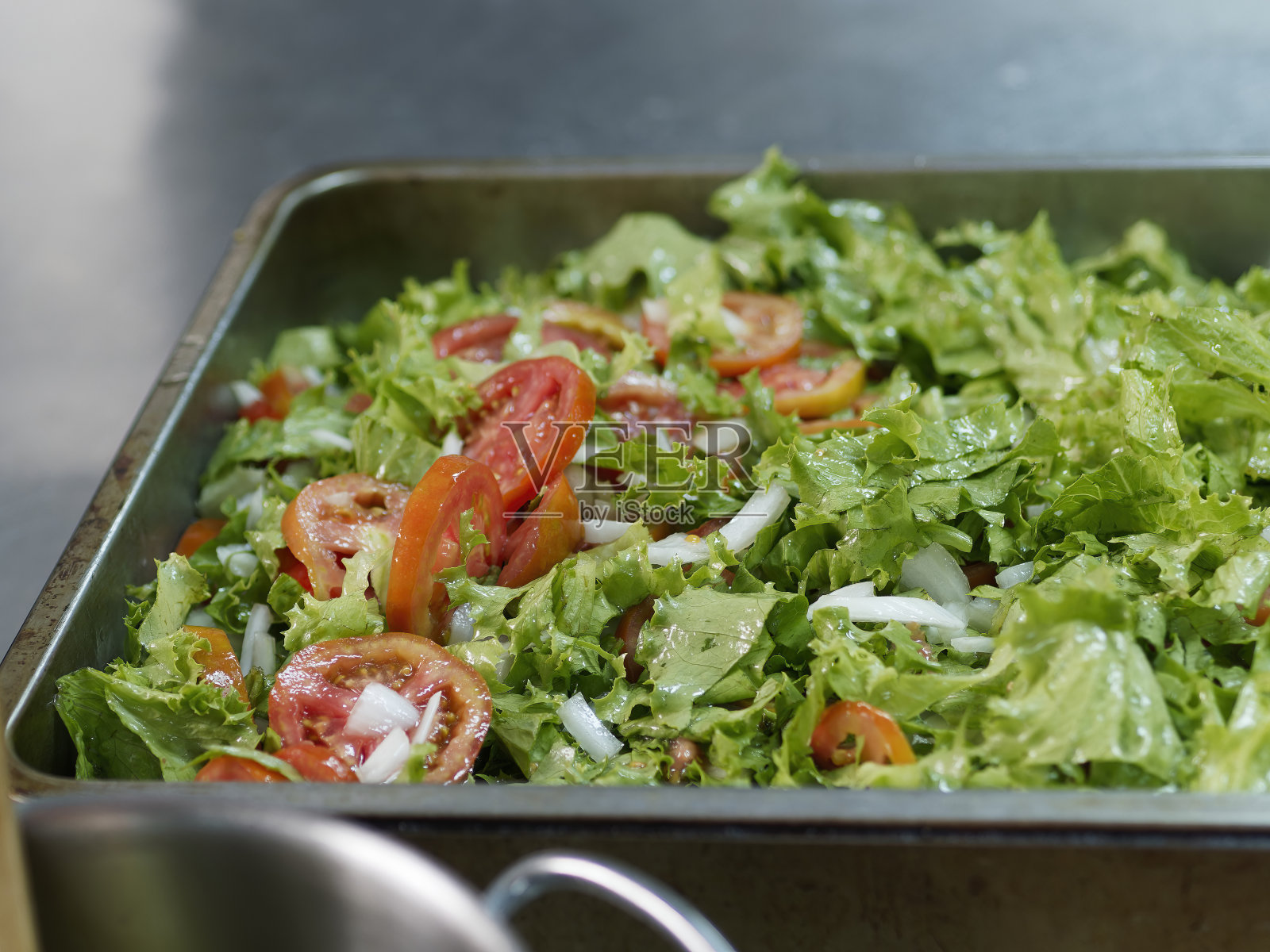绿色沙拉配番茄和胡萝卜。健康的沙拉准备好了。白色餐桌上的混合蔬菜沙拉不加调料。照片摄影图片