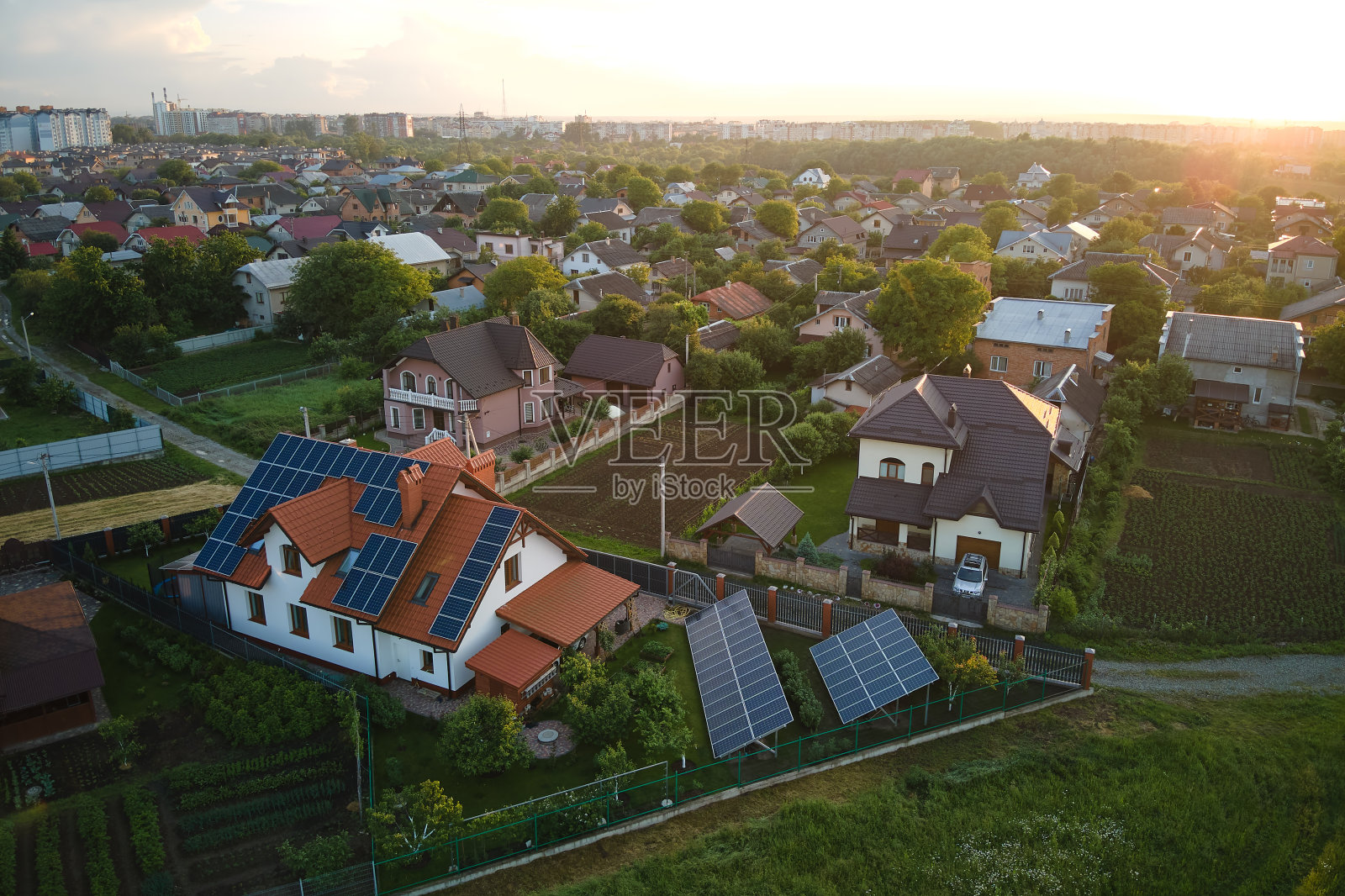 在郊区农村城镇地区,私人住宅屋顶覆盖太阳能光伏板,以产生清洁的生态电能。自主住宅的概念照片摄影图片