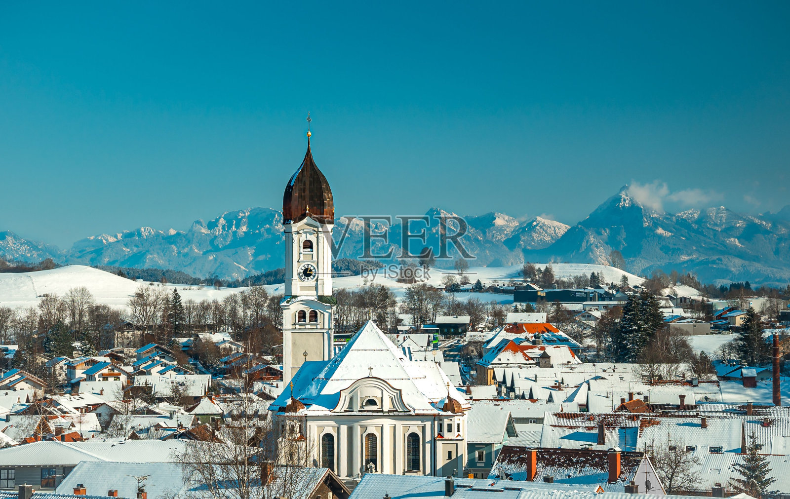 阿尔卑斯山前的圣安德烈亚斯教堂在一个阳光明媚的冬日内塞尔旺照片摄影图片