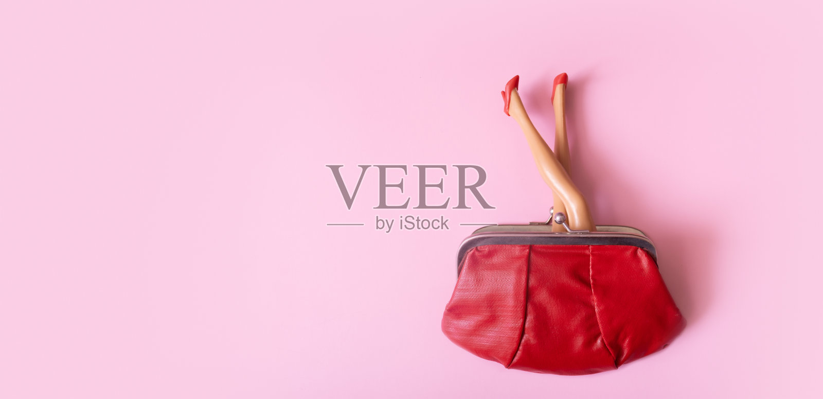 娃娃腿在红色鞋子伸出钱包顶视图。创意女性购物或理财概念照片摄影图片