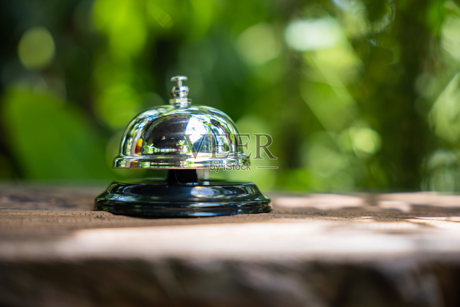 复古钟声召唤员工在户外花园与绿叶照片摄影图片