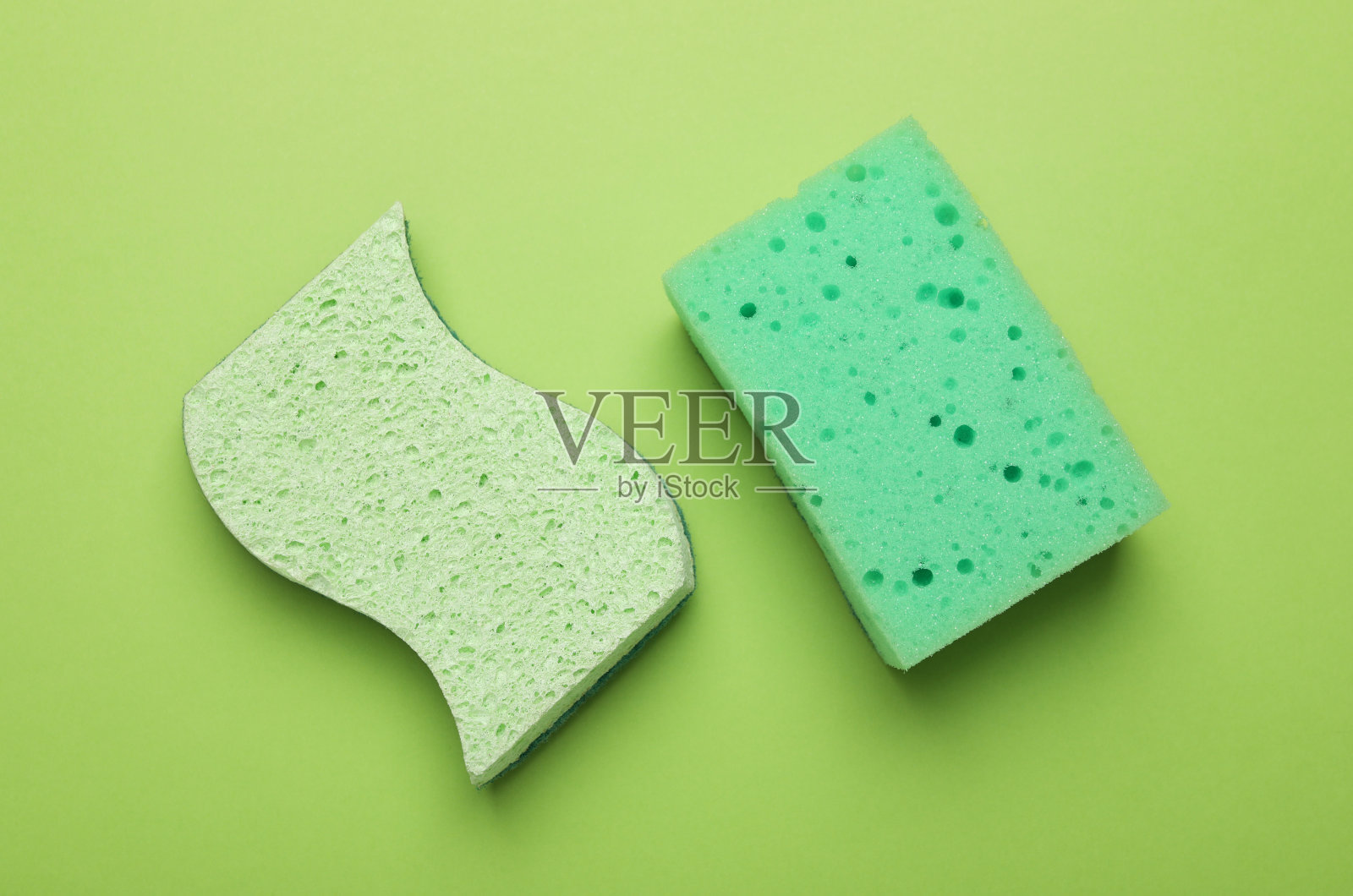 将海绵涂在绿色背景上,平铺照片摄影图片