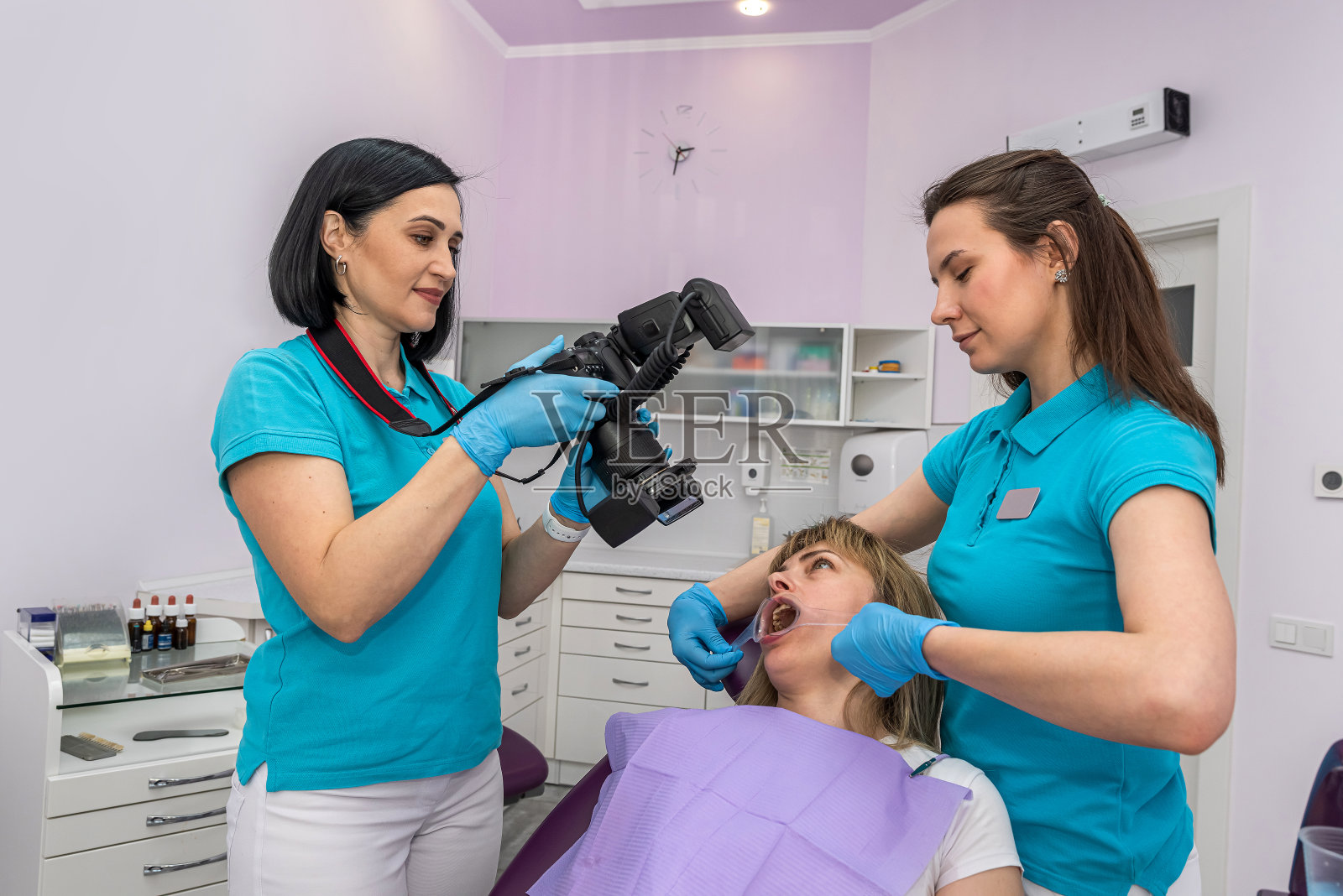 小女孩患者在牙科拍摄牙齿照片,以比较治疗过程。照片摄影图片