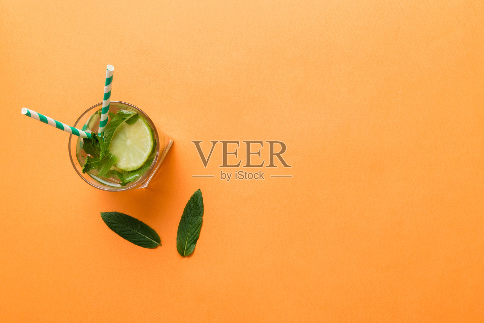 凯匹林纳,莫吉托鸡尾酒,伏特加或苏打饮料与莱姆,薄荷和稻草的桌子背景。清爽的薄荷和酸橙饮料在玻璃顶视图平铺照片摄影图片