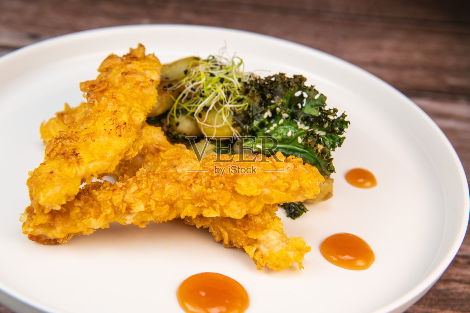 面包鸡柳和土豆配芝麻羽衣甘蓝片和糖醋酱的食谱照片摄影图片