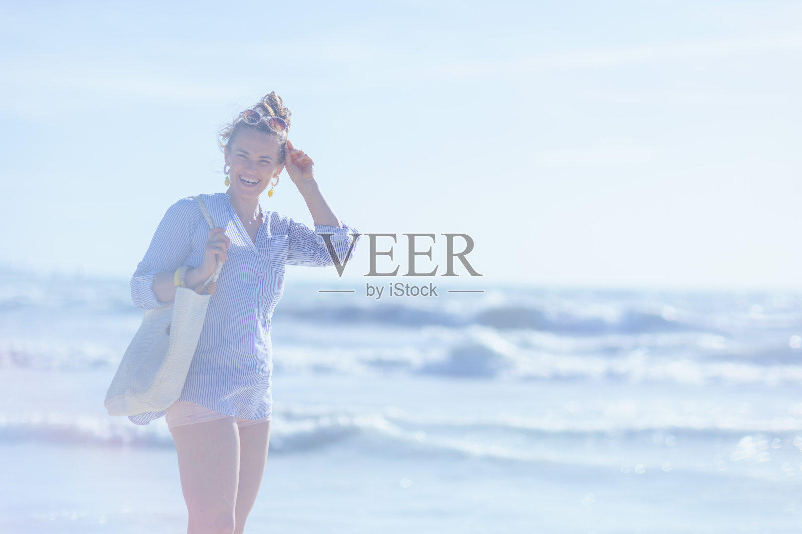 快乐时尚的40岁女人在海滩照片摄影图片