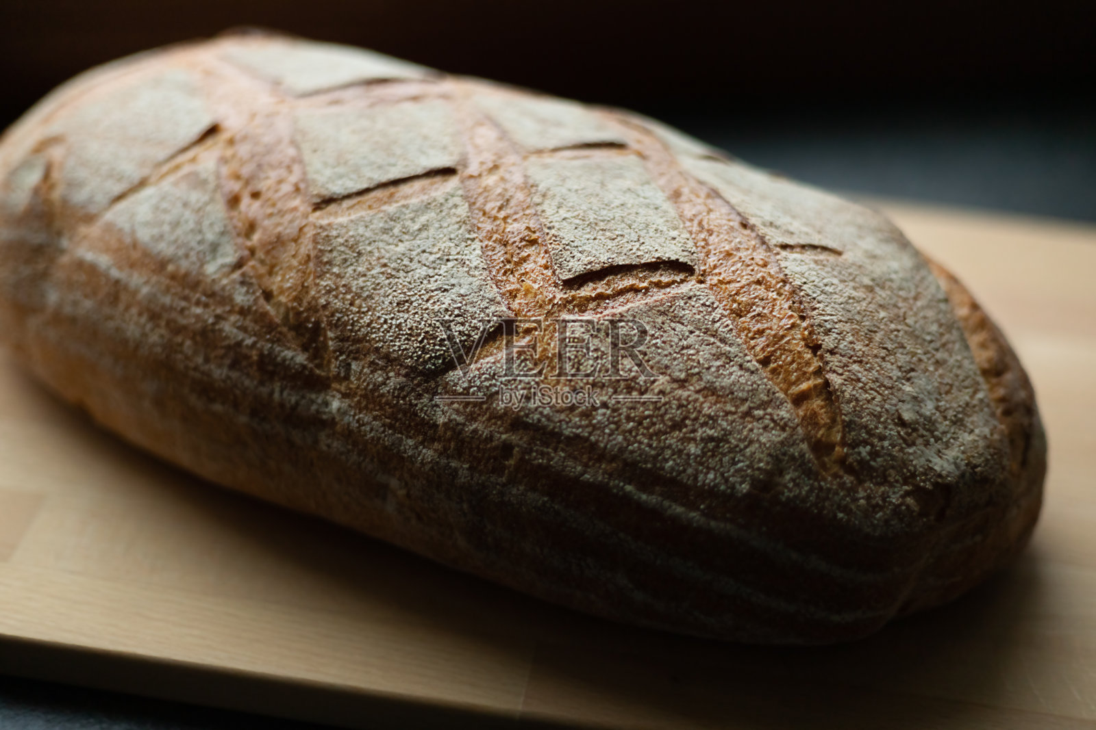 深灰色的餐桌上,近景,角度视角,整个刚烤好的酸面包照片摄影图片