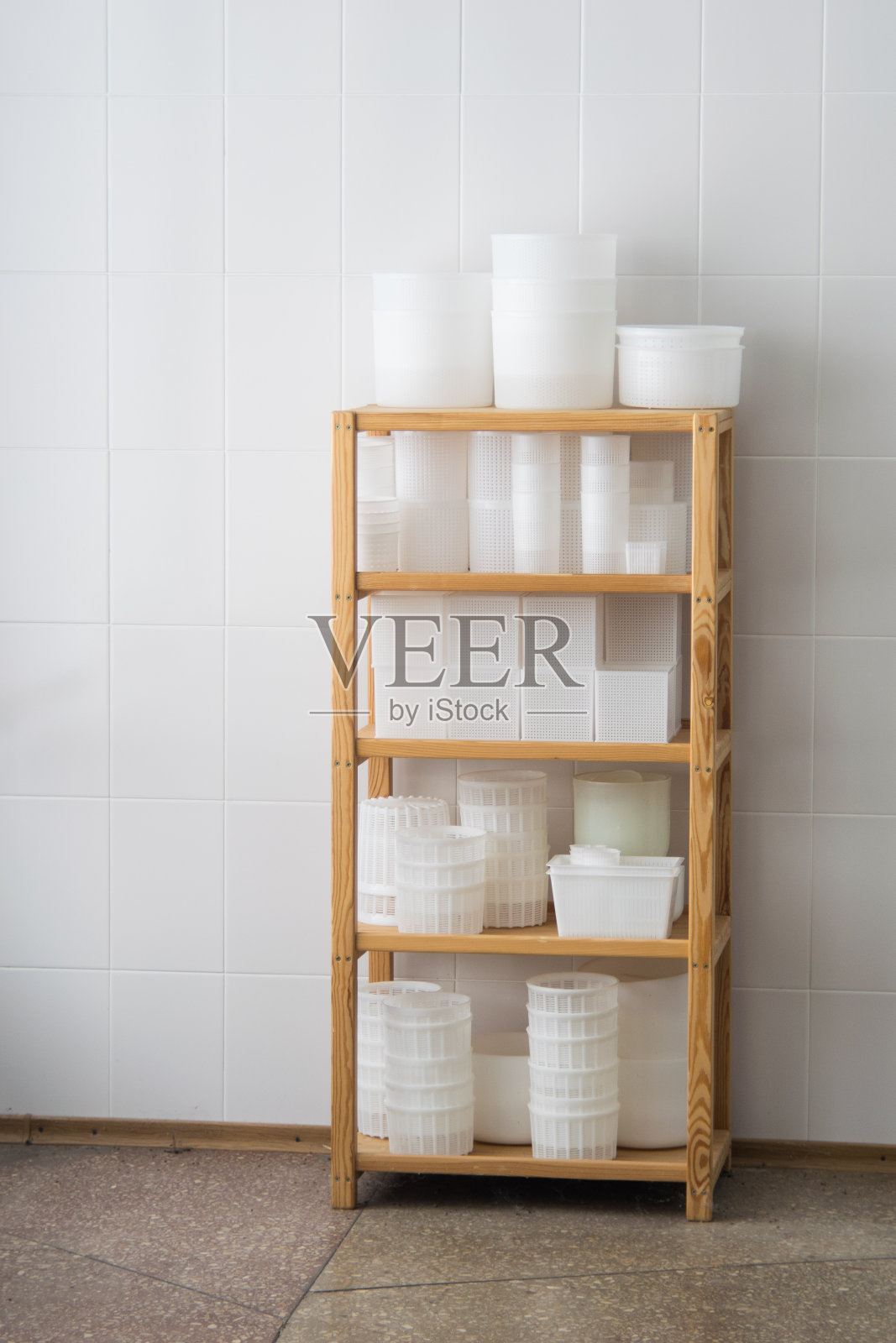 白色的塑料奶酪模板,木架上的塑形玻璃杯。私营小型乳酪厂照片摄影图片