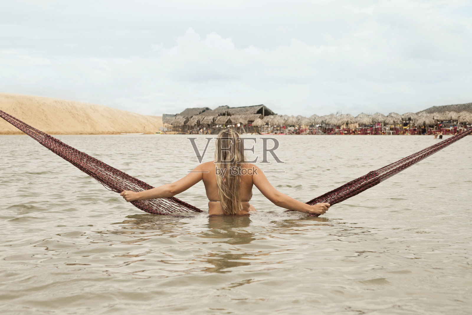 在巴西Jericoacoara的Tatajuba泻湖,一名女子躺在吊床上。照片摄影图片