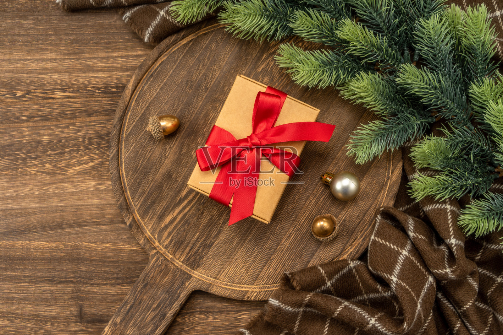 圣诞礼物在木制砧板与圣诞装饰。照片摄影图片