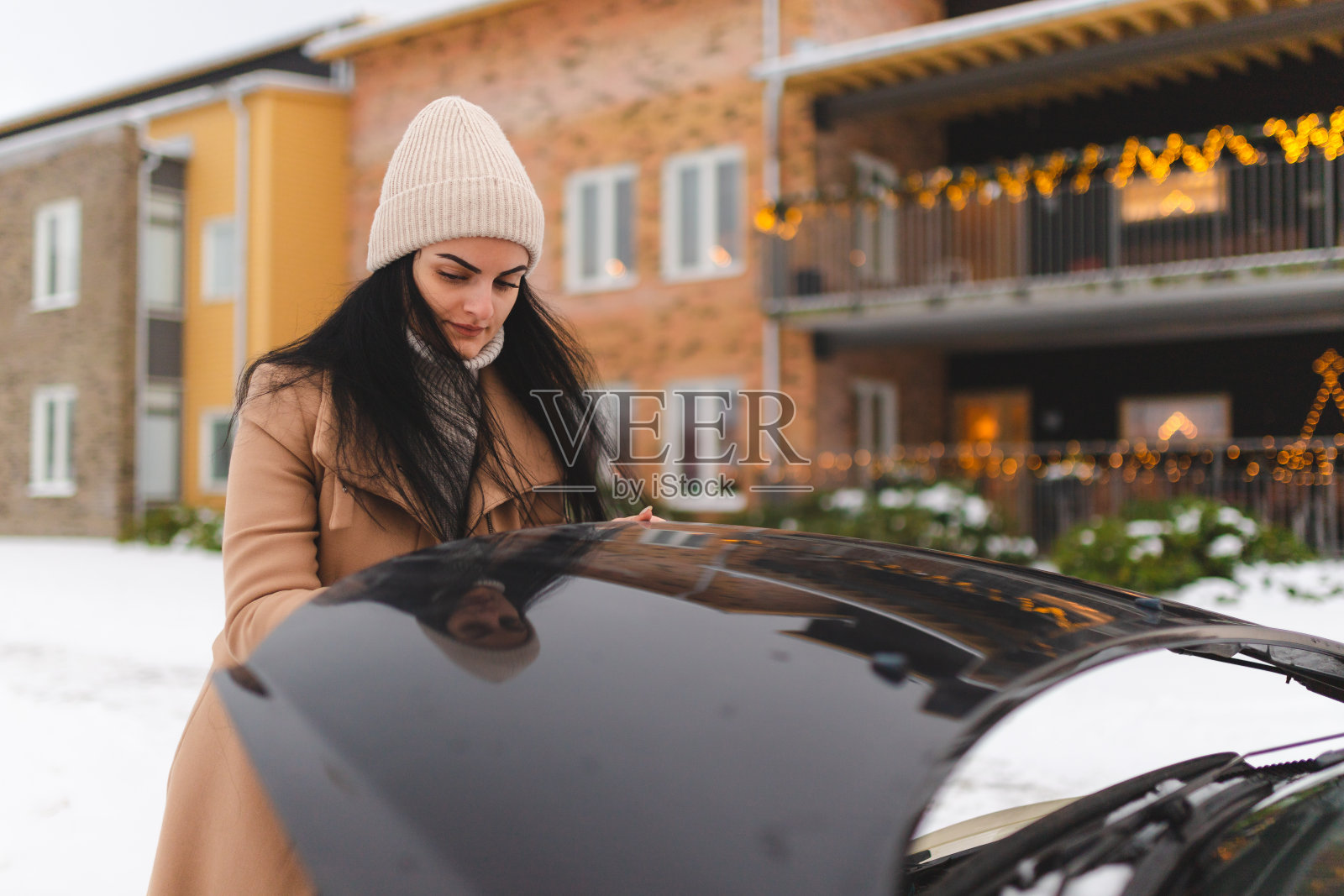 年轻女子在户外打开汽车罩照片摄影图片