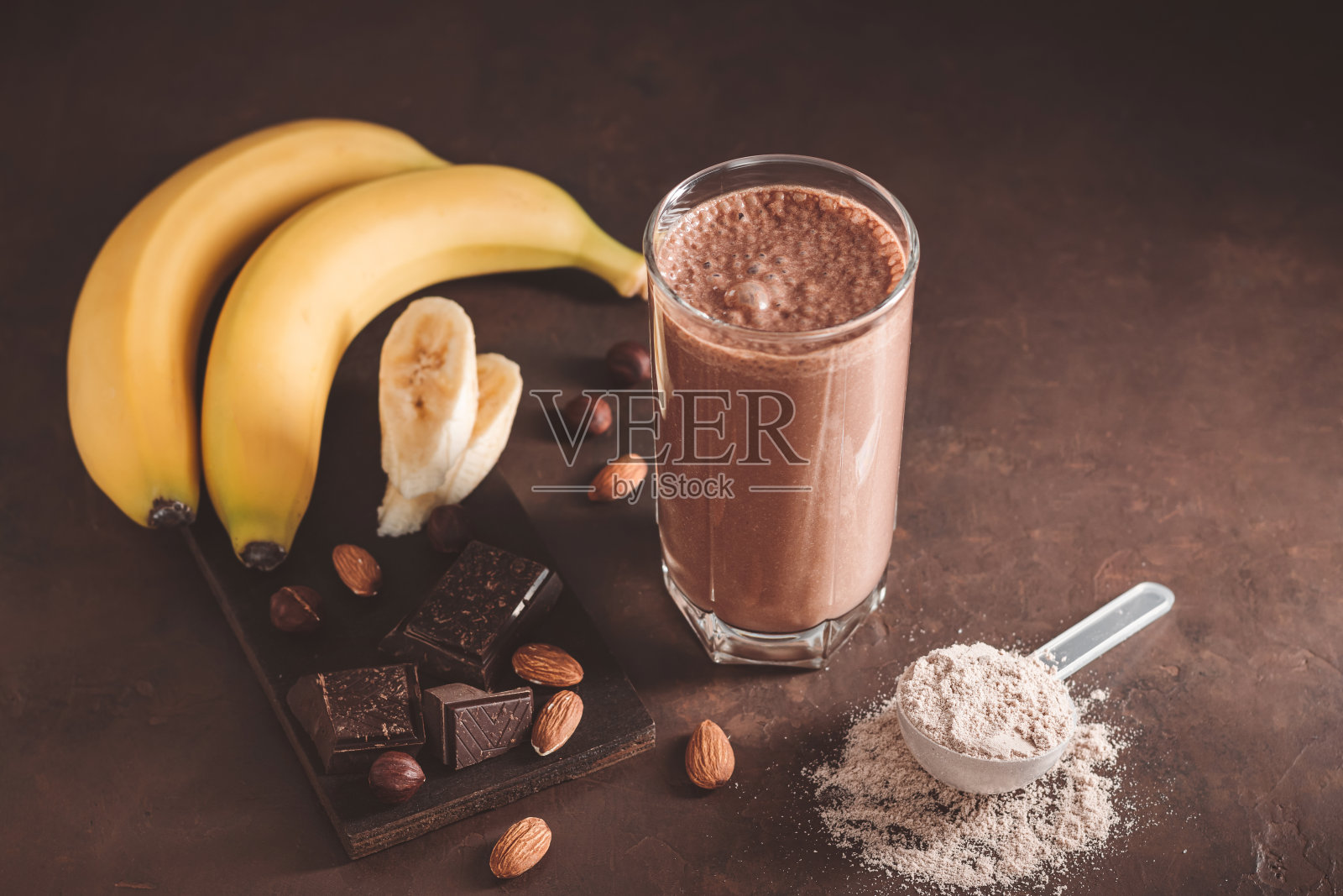 巧克力奶昔加香蕉,蛋白粉和坚果,黑色背景照片摄影图片