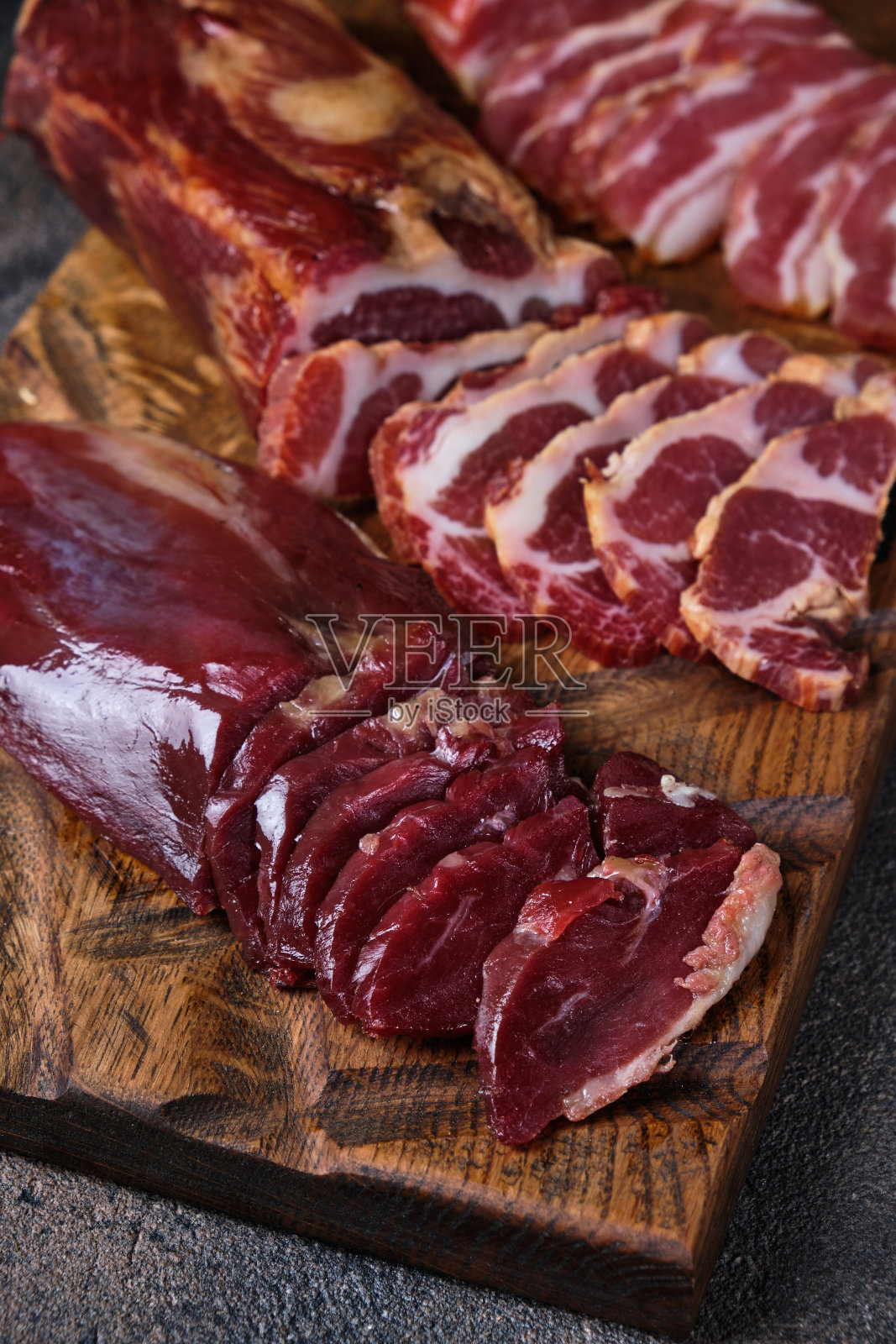 把熏过的肉块放在木板上,再切几块照片摄影图片