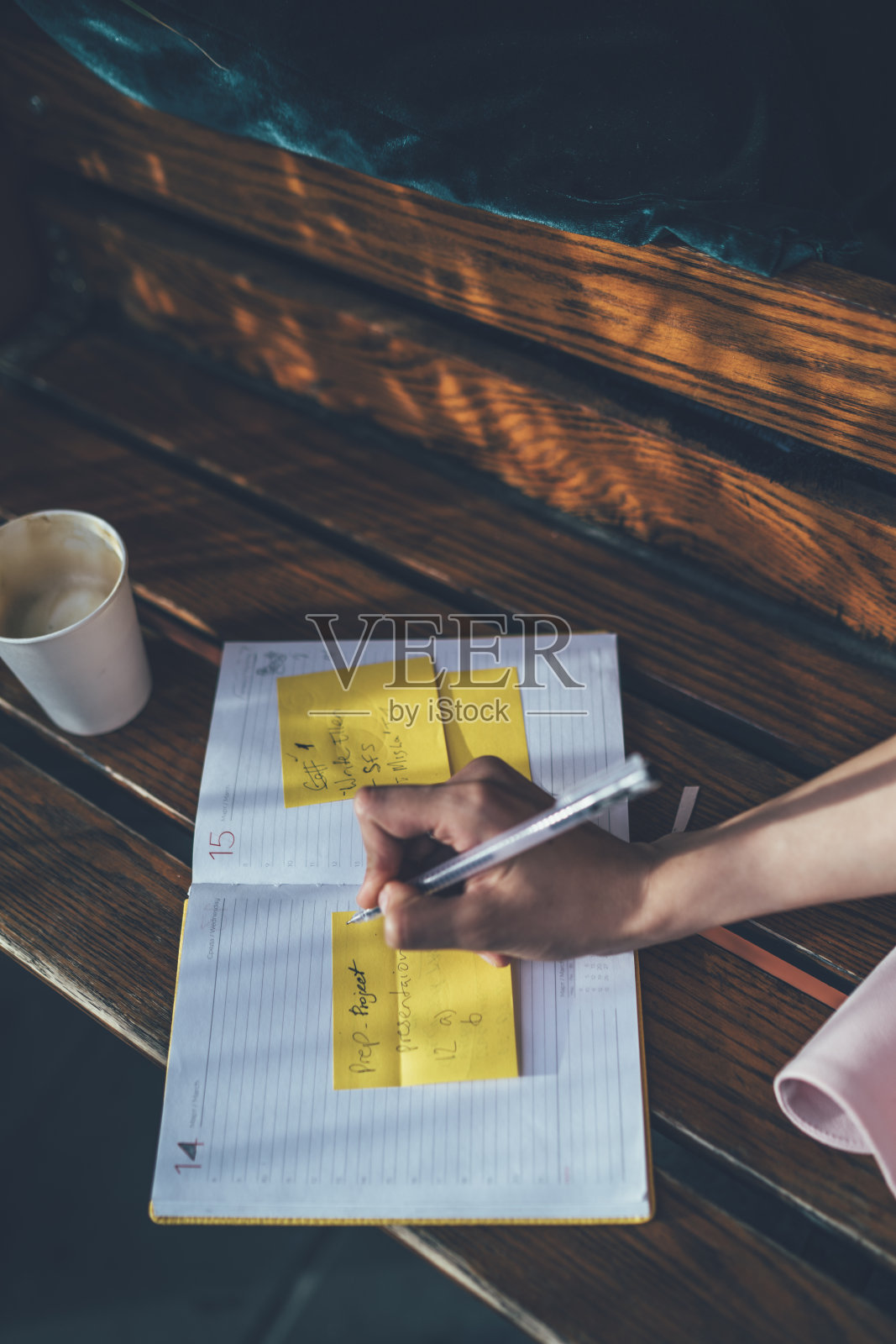 裁剪图像聪明的女学生使用教科书计划写备忘录在通知贴纸在学习过程中,选择性关注纸记事本和手记项目信息照片摄影图片