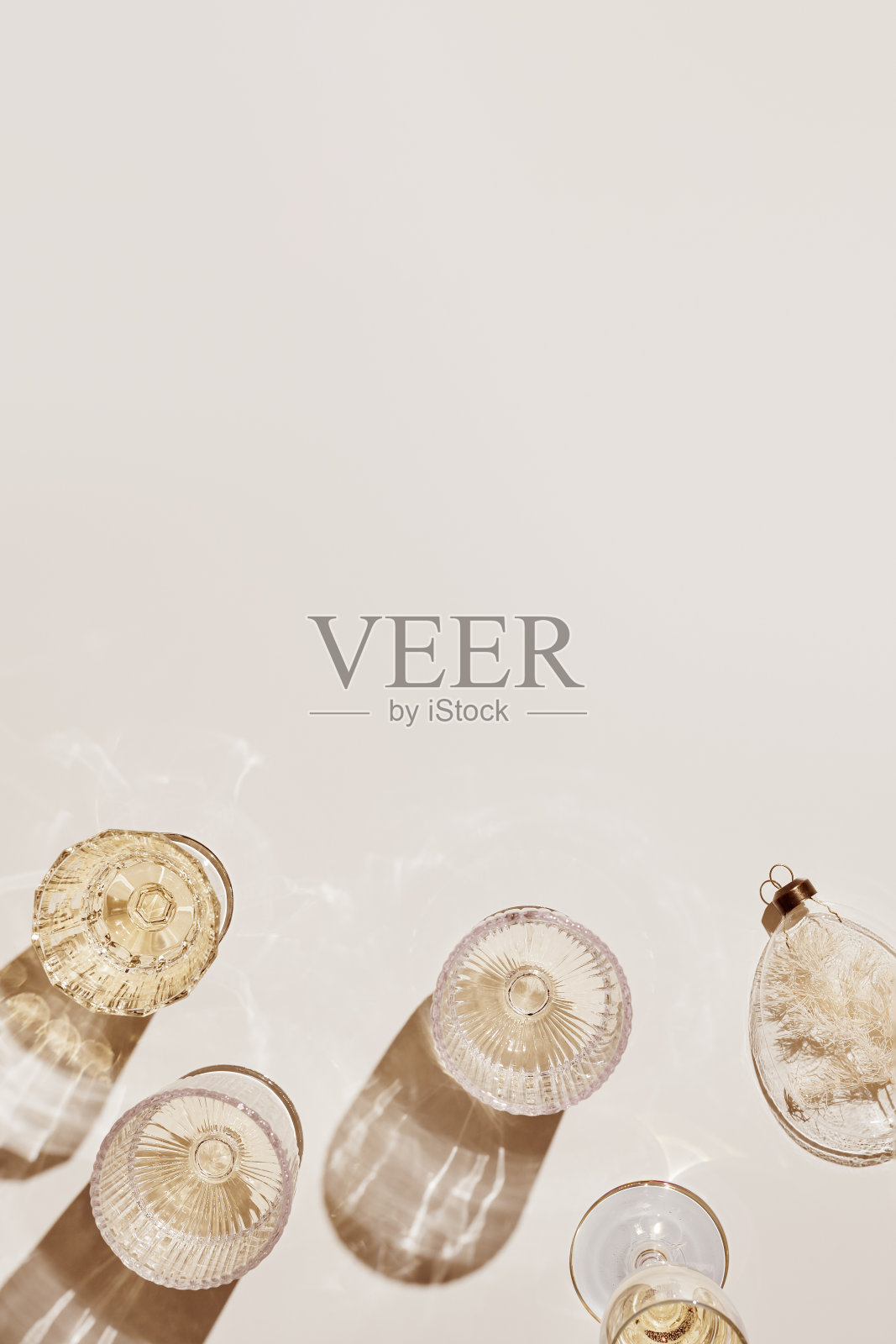 新年假期平铺,白色气泡酒在不同的水晶酒杯,节日香槟饮料,米色金色的美学布局,新年假期活动或派对的概念,阴影照片摄影图片